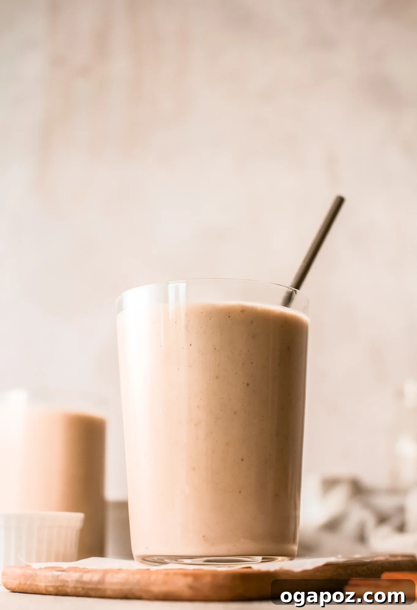 Quick & Healthy Oat Smoothies 7 A glass of oat smoothie with a straw, garnished with a light sprinkle of oats.