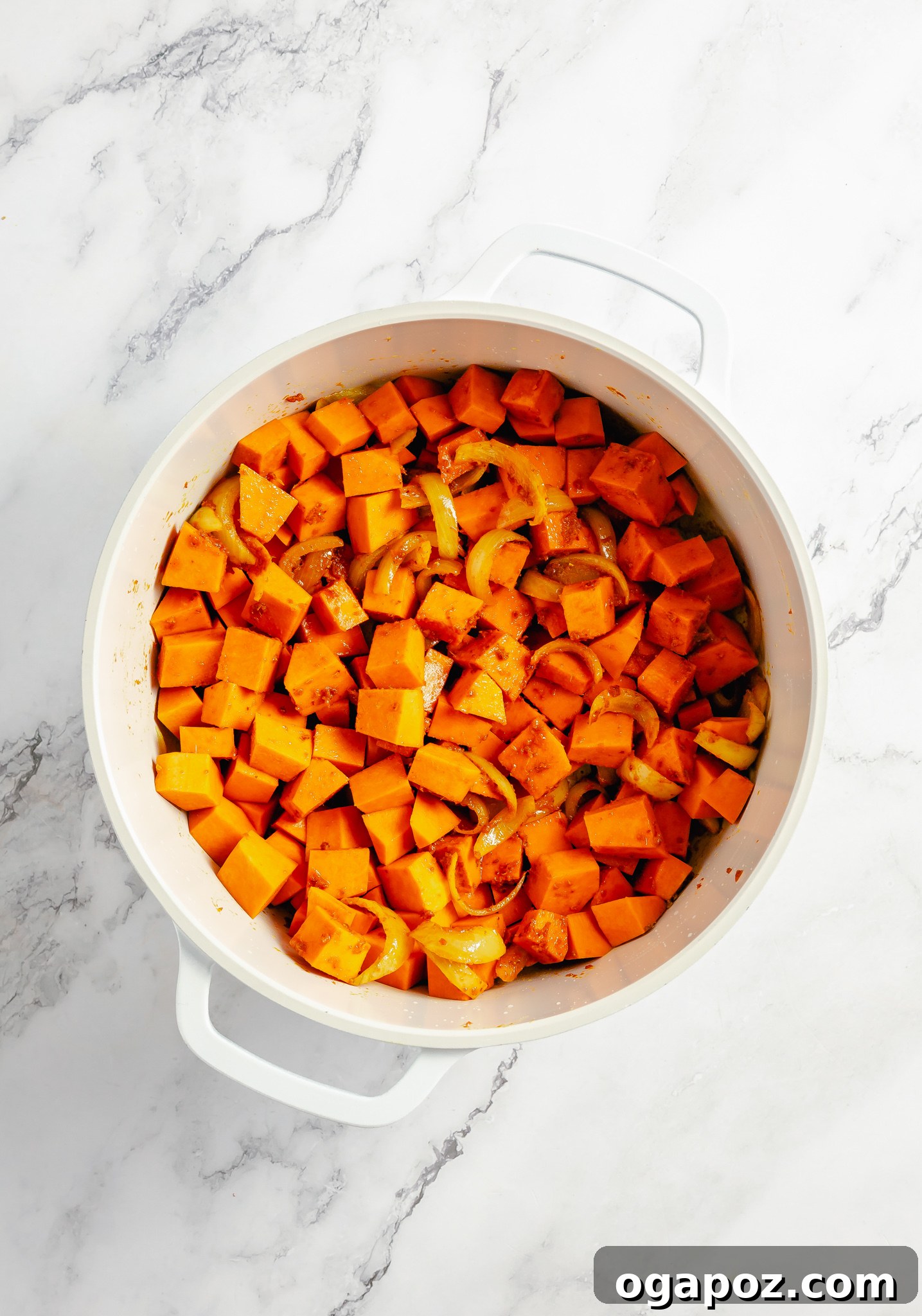 Diced pumpkin simmering in a pot with curry sauce.
