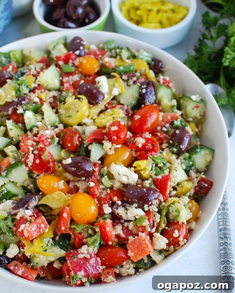 Santorini Sunset Quinoa Salad 2 Vibrant Greek Quinoa Salad in a white bowl, showcasing fresh ingredients like tomatoes, cucumbers, and feta