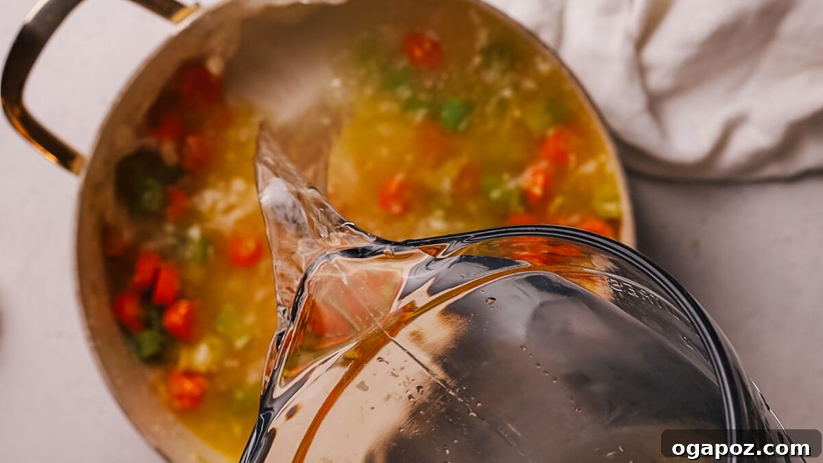 Deliciously Simple Ham Bone Soup Hearty and Flavorful 5 Step 2: Adding minced garlic and a ham bone to the sautéed vegetables in the pot.