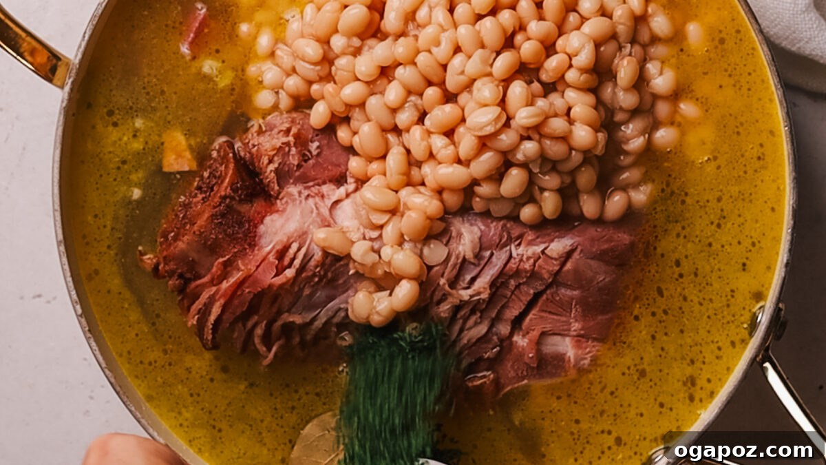 Deliciously Simple Ham Bone Soup Hearty and Flavorful 6 Step 3: Pouring chicken broth into the pot with ham bone and vegetables, ready for simmering.