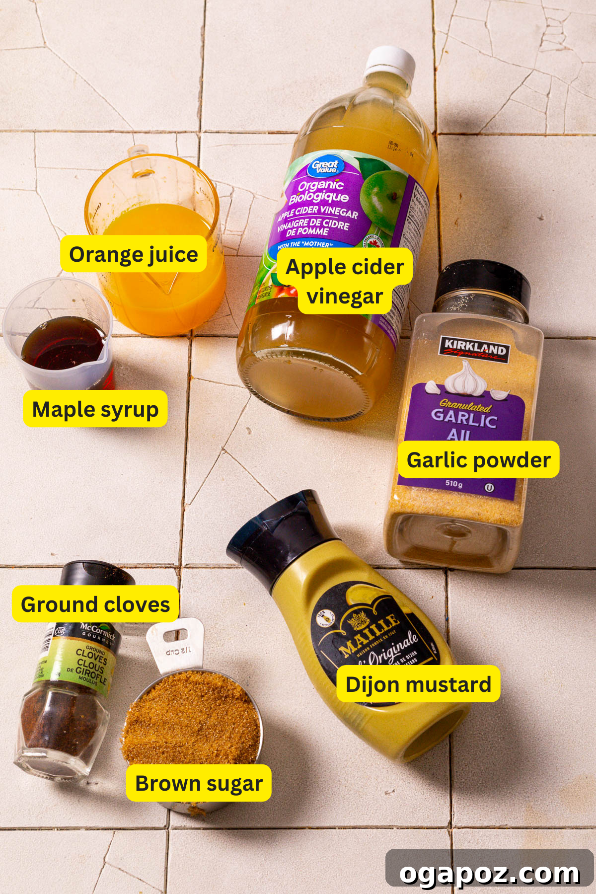The Perfect Ham Glaze 3 Ingredients for ham glaze laid out on a kitchen counter, featuring brown sugar, maple syrup, orange juice, Dijon mustard, apple cider vinegar, garlic powder, and ground cloves.