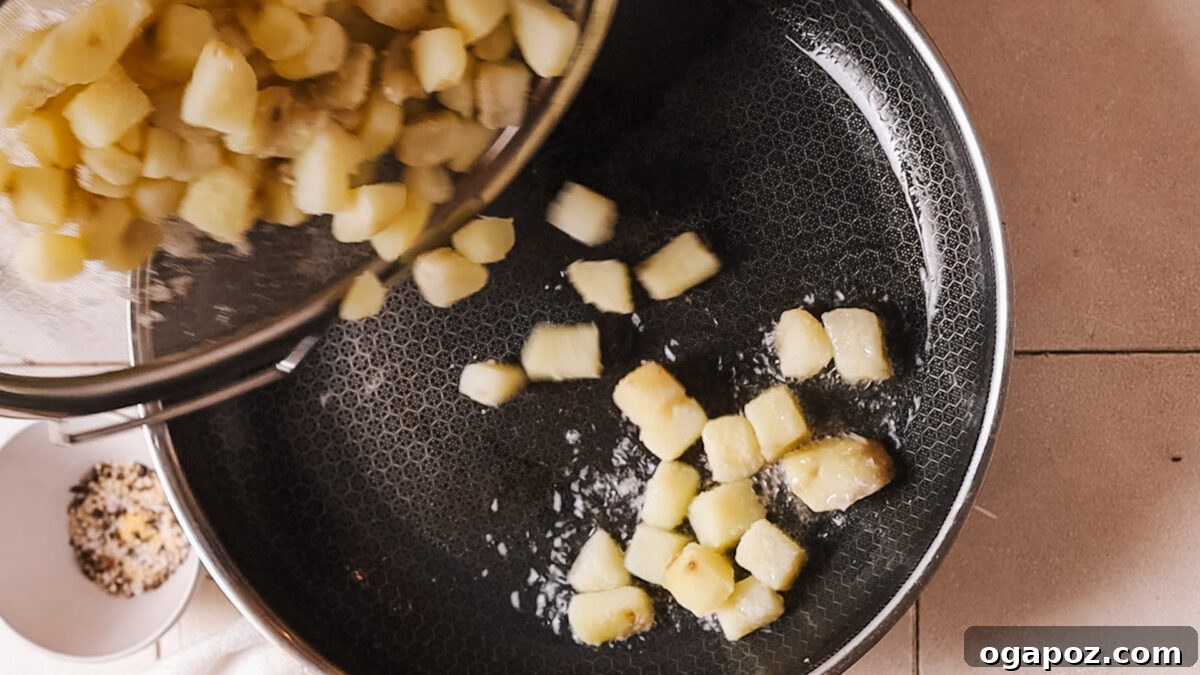 Crispy Fluffy French Fries 6 Adding potatoes to hot oil in a pan