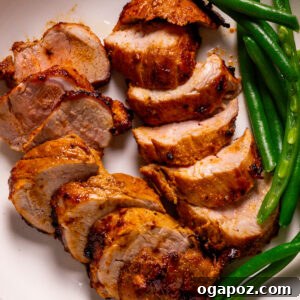 Air fryer pork tenderloin recipe plated with green beans.