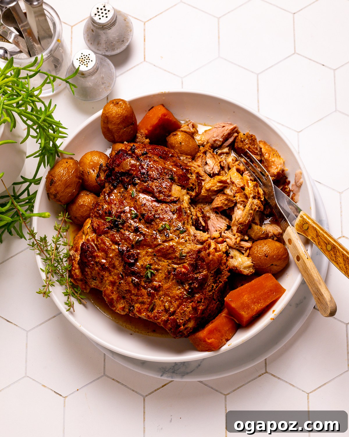 Melt in Your Mouth Slow Cooked Pork Shoulder 11 Slow cooker pork shoulder on a plate with tender vegetables, drizzled with gravy.