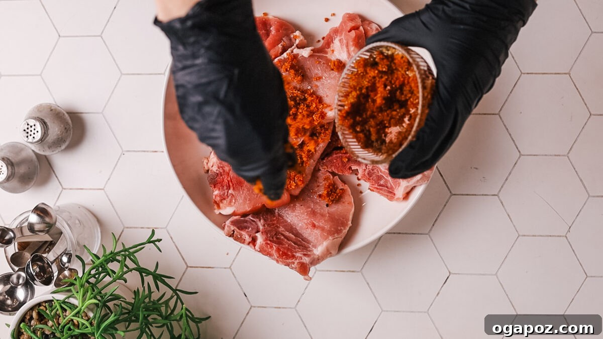 Succulent Air Fryer Pork Chops Every Time 6 applying rub on pork chop