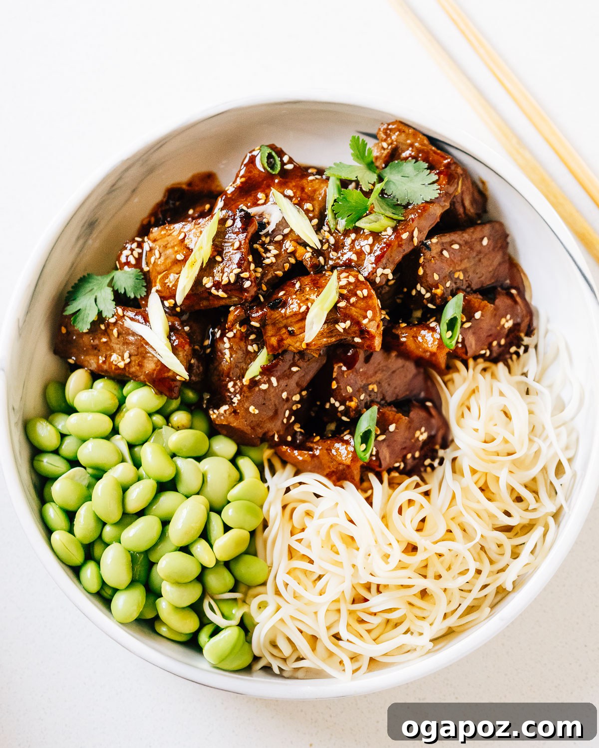 Mouthwatering Boneless Beef Ideas 4 Beef teriyaki in a bowl with noodles and edamame, garnished beautifully.
