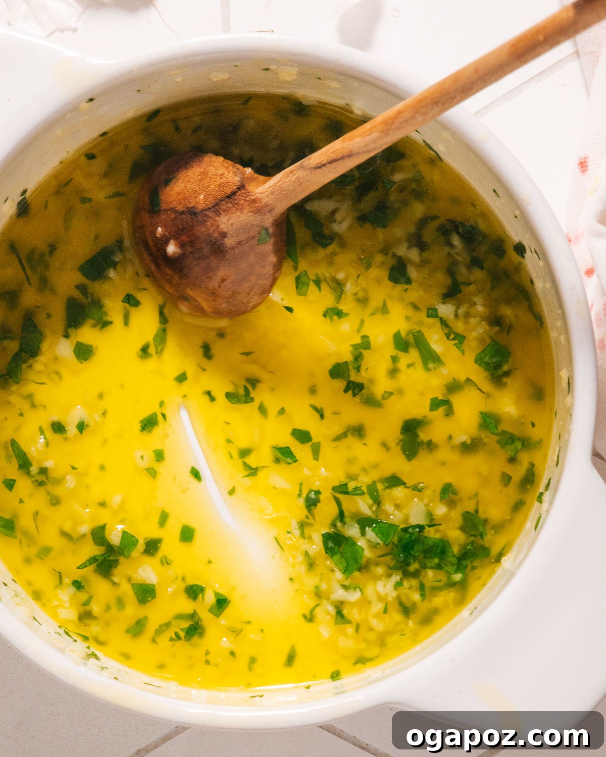 The Ultimate Chicken Wing Sauce Collection 13 Garlic butter sauce simmering in a pot with a spoon.