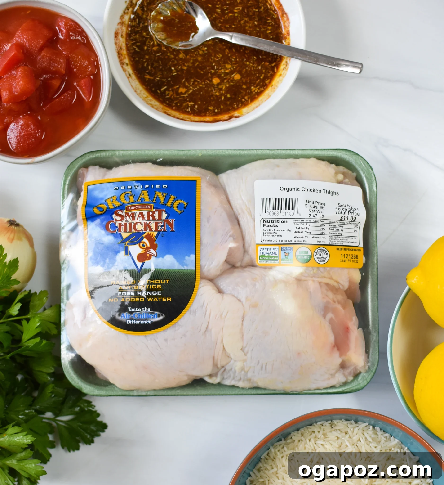 Akdeniz Lezzetleriyle Tek Tencere Tavuk Pilavı 3 A collection of fresh ingredients laid out for One Pot Mediterranean Chicken and Rice, including chicken thighs, spices, lemon, and vegetables.