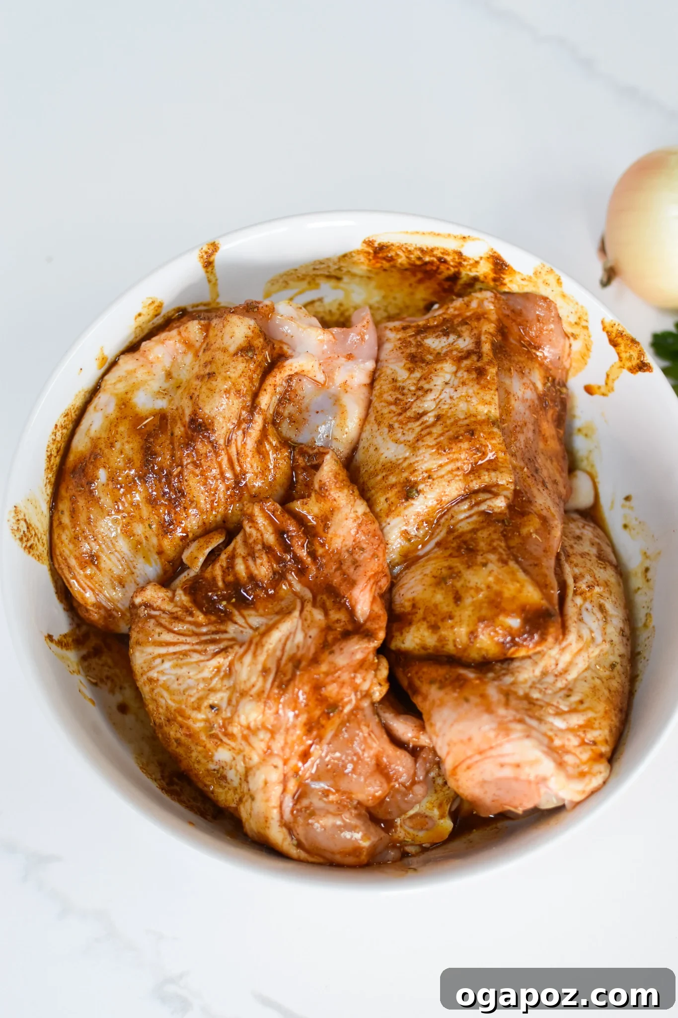Akdeniz Lezzetleriyle Tek Tencere Tavuk Pilavı 5 Marinated chicken thighs resting in a bowl, ready for cooking.