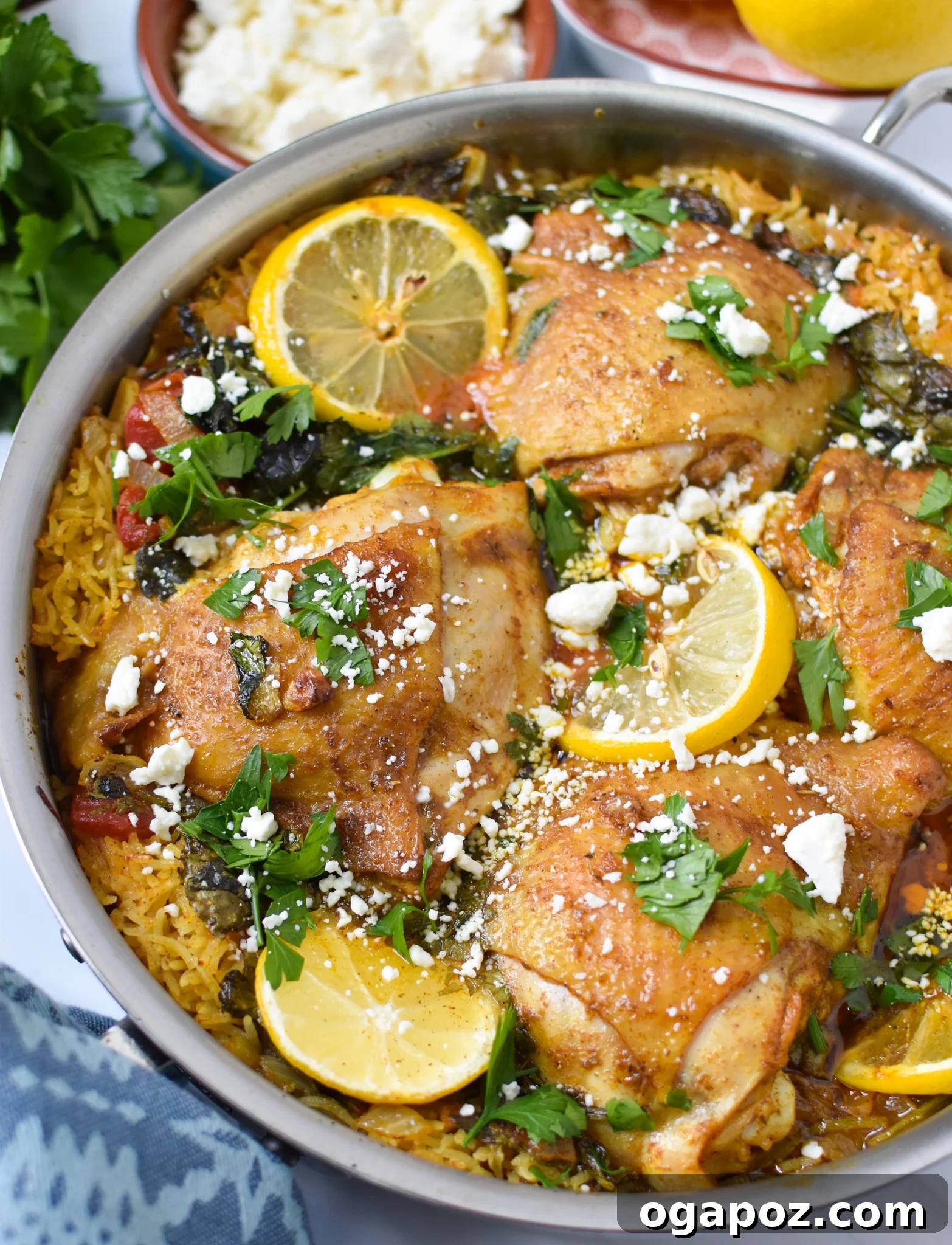Akdeniz Lezzetleriyle Tek Tencere Tavuk Pilavı 8 A close-up of One Pot Mediterranean Chicken and Rice served, with a generous topping of crumbled feta cheese and fresh parsley.