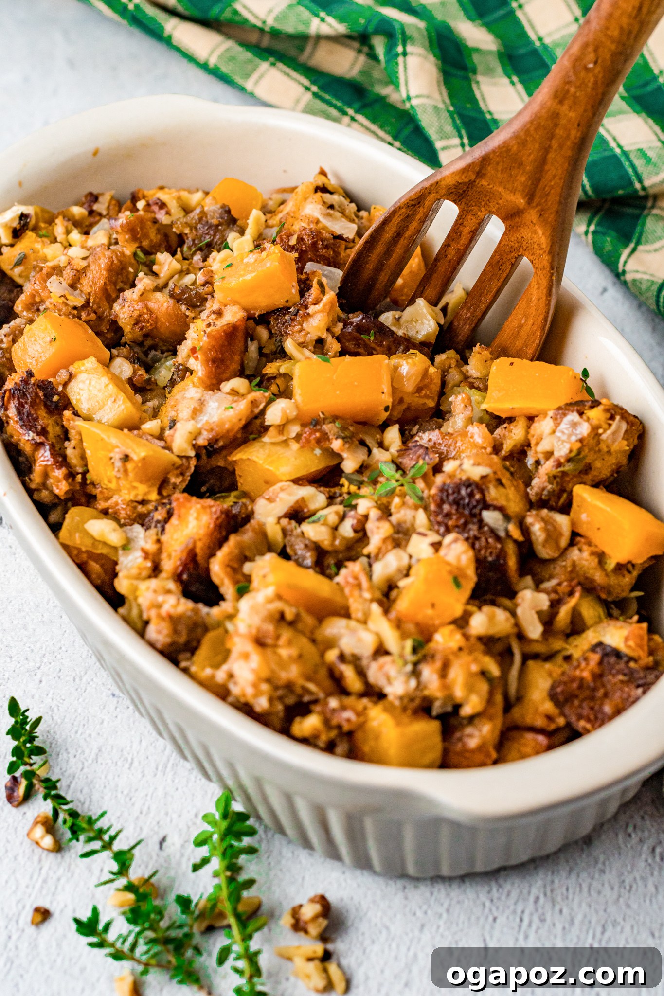 Sweet and Savory Butternut Squash Stuffing 2 Golden brown Butternut Squash Stuffing in a white serving bowl, garnished with fresh herbs, ready for the holiday table.