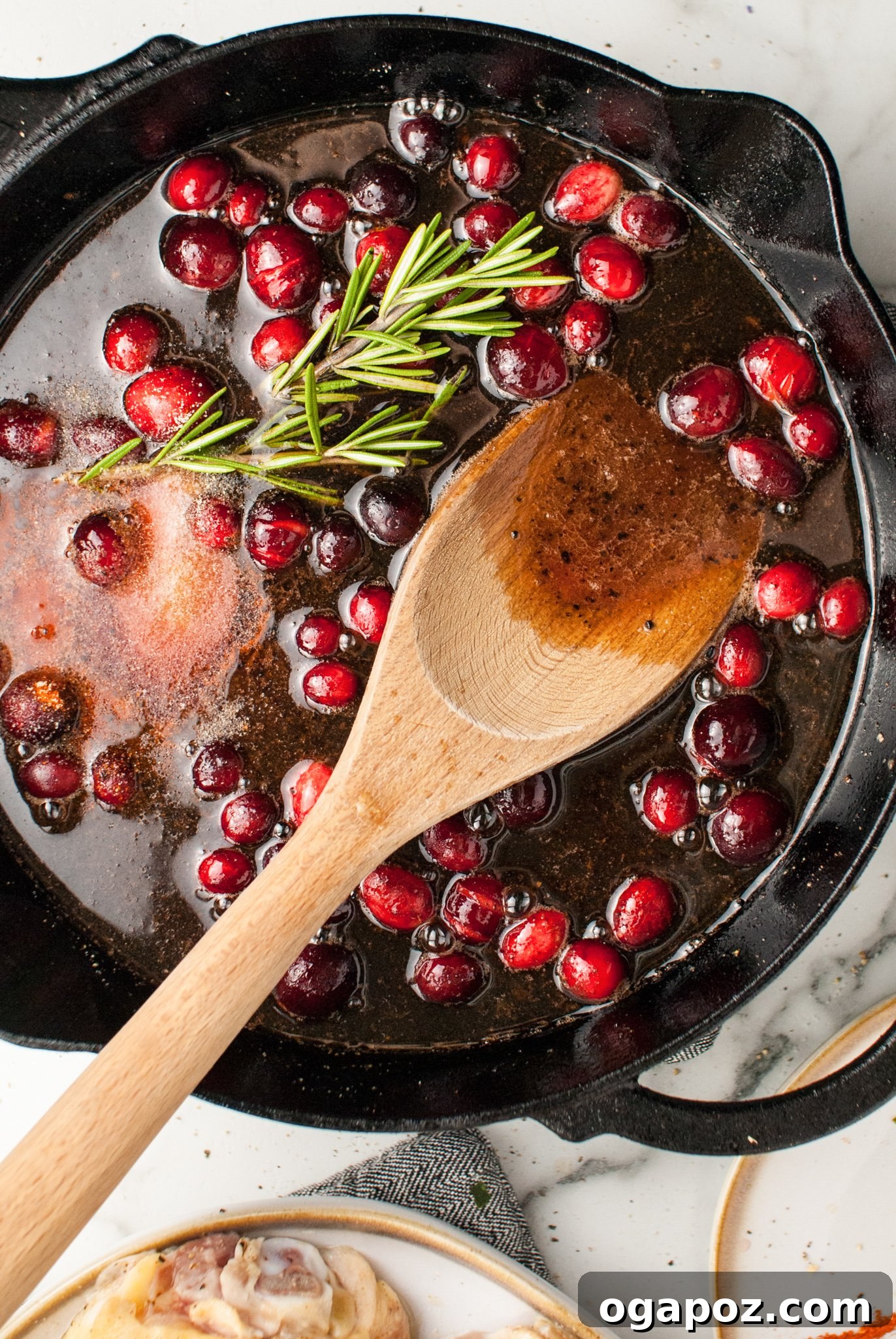 Effortless Cranberry Glazed Chicken Thighs 5 Easy Baked Chicken Thighs cranberry sauce simmering in a skillet.
