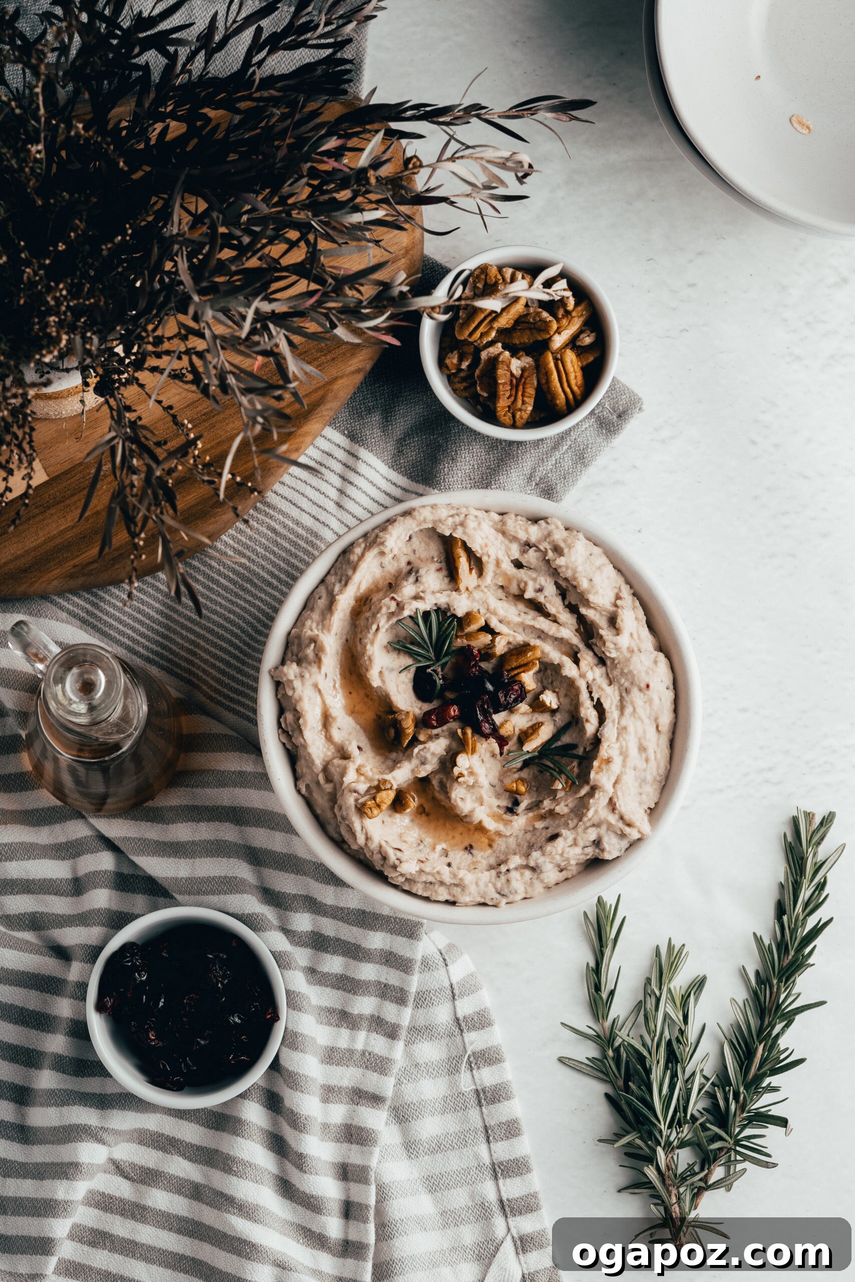 Tangy Cranberry White Bean Hummus 6 Overhead view of White Bean Hummus with Cranberry, garnished with pecans and rosemary.