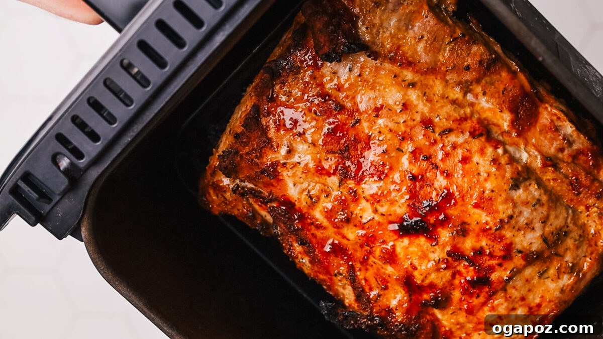 Perfect Air Fryer Pork Loin 7 Placing the seasoned pork loin into the air fryer basket.