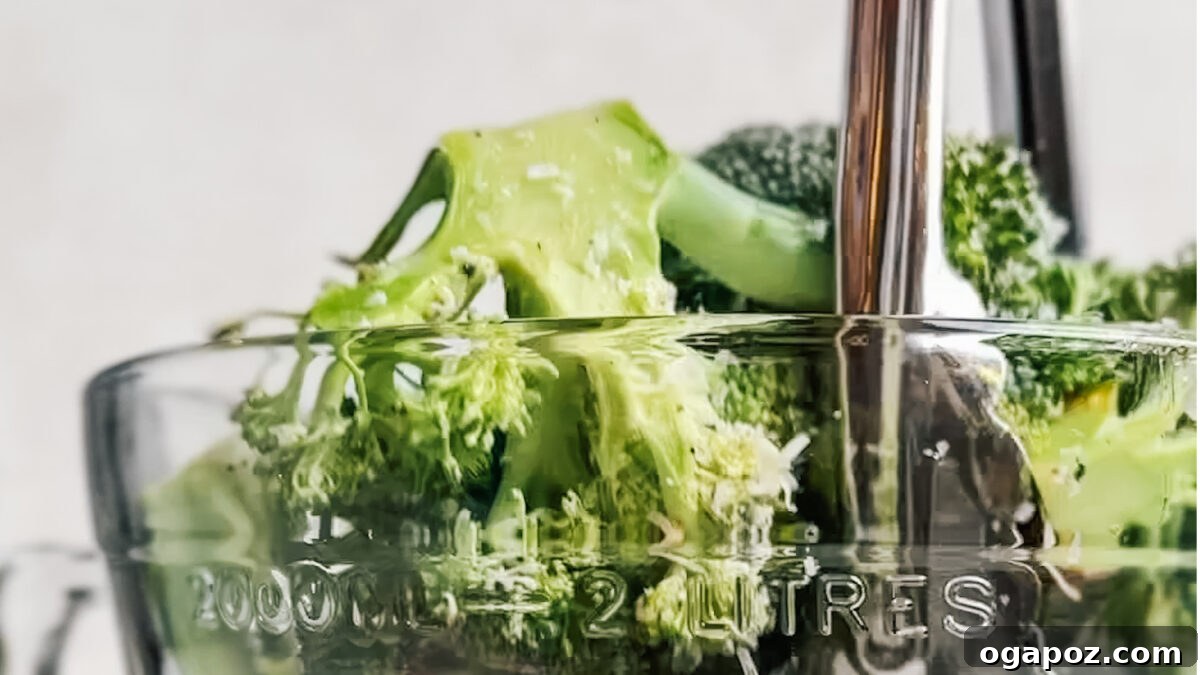 Effortlessly Crispy Air Fryer Broccoli 4 Broccoli florets being seasoned in a bowl.
