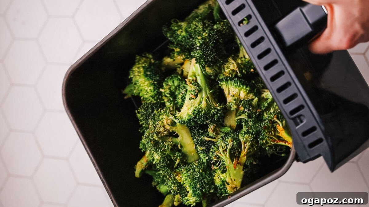 Effortlessly Crispy Air Fryer Broccoli 5 Broccoli being placed into an air fryer basket.