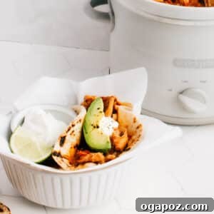 Shredded chicken tacos cooked in a crockpot, ready to be assembled with toppings.
