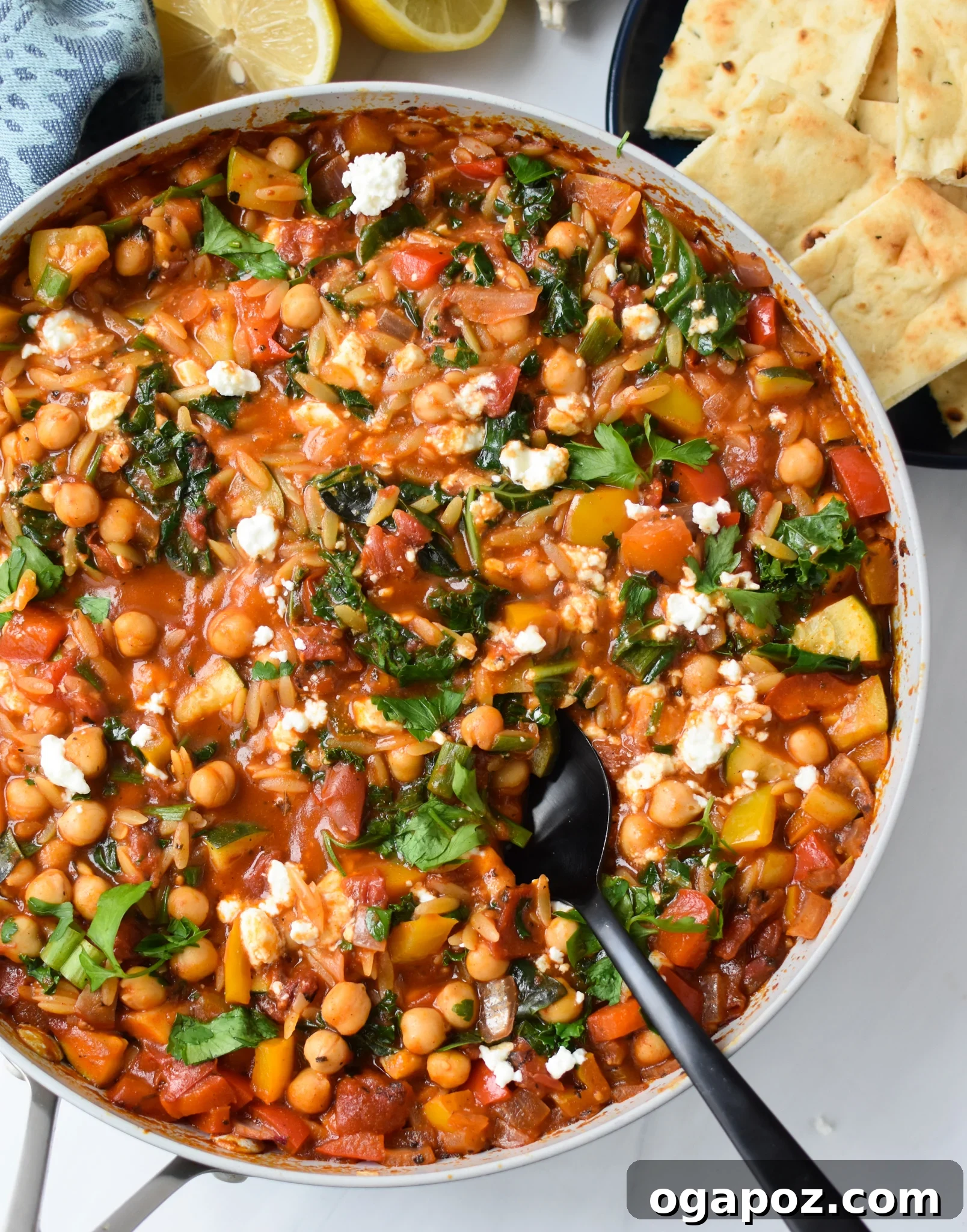 A pan filled with colorful Mediterranean Orzo Pasta Recipe, garnished with fresh herbs.
