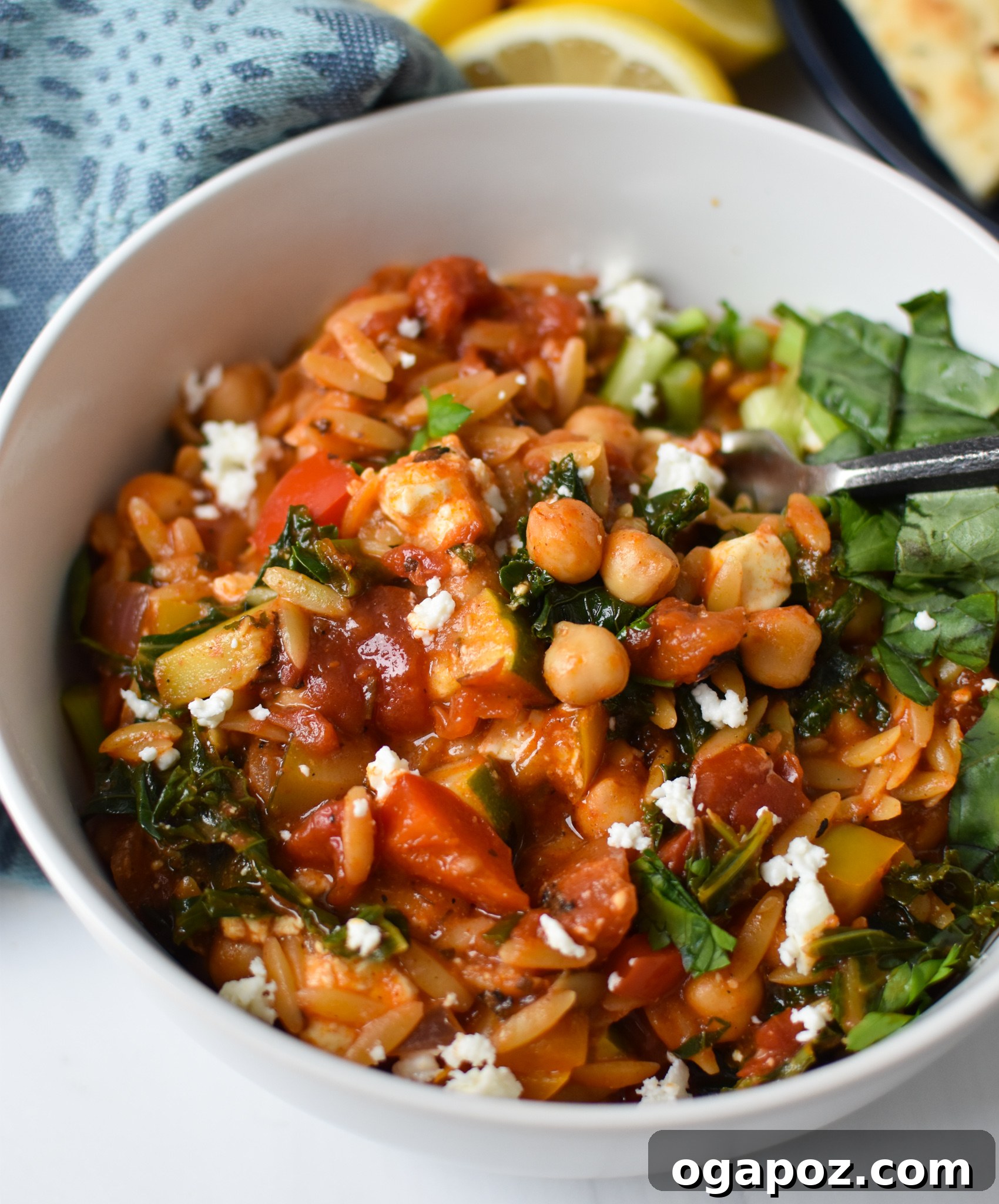 A bowl of Mediterranean Orzo Pasta Recipe, garnished with fresh feta and herbs, ready to be served.