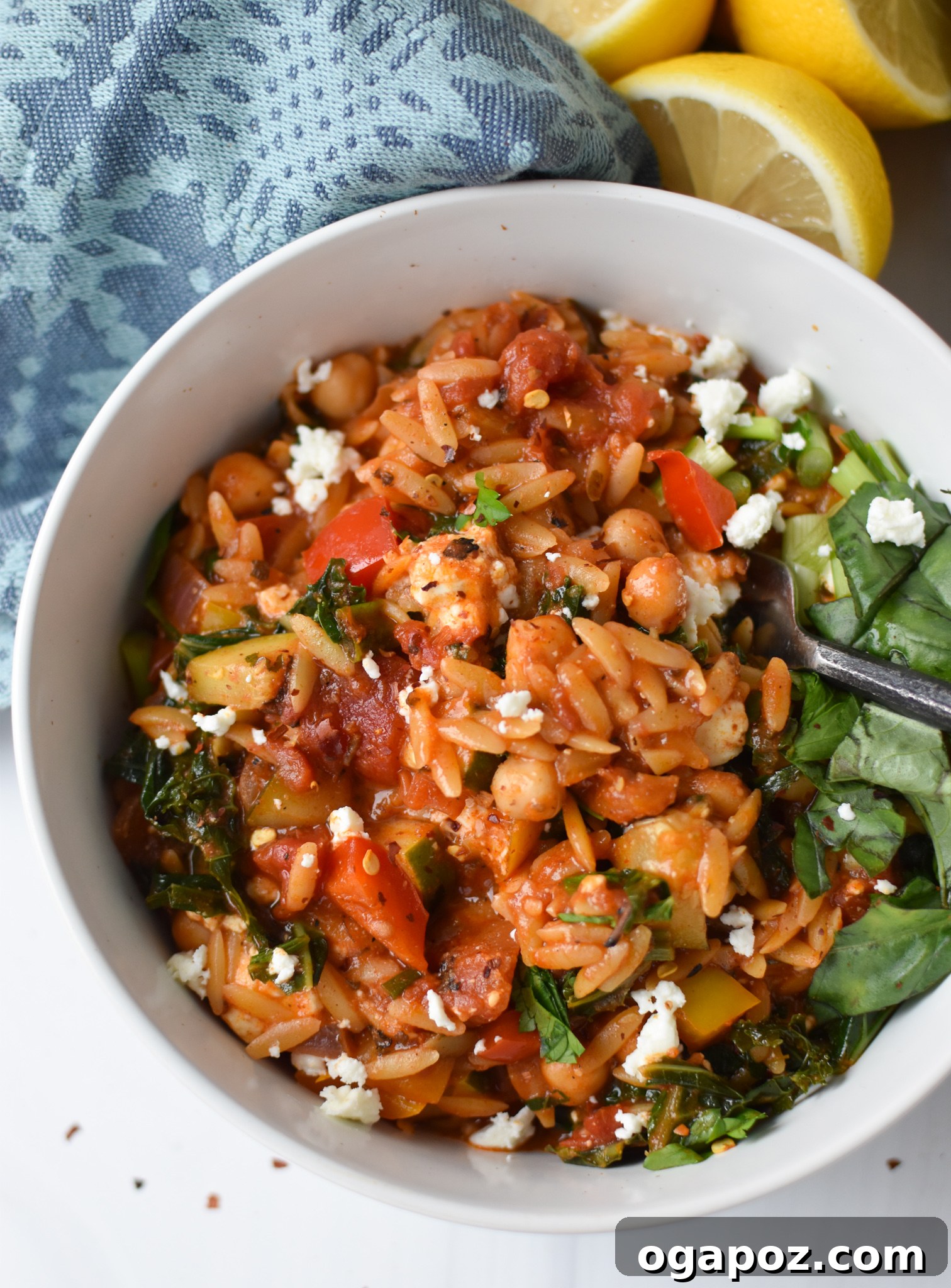 A serving of Mediterranean Orzo Pasta Recipe in a bowl with a spoon.