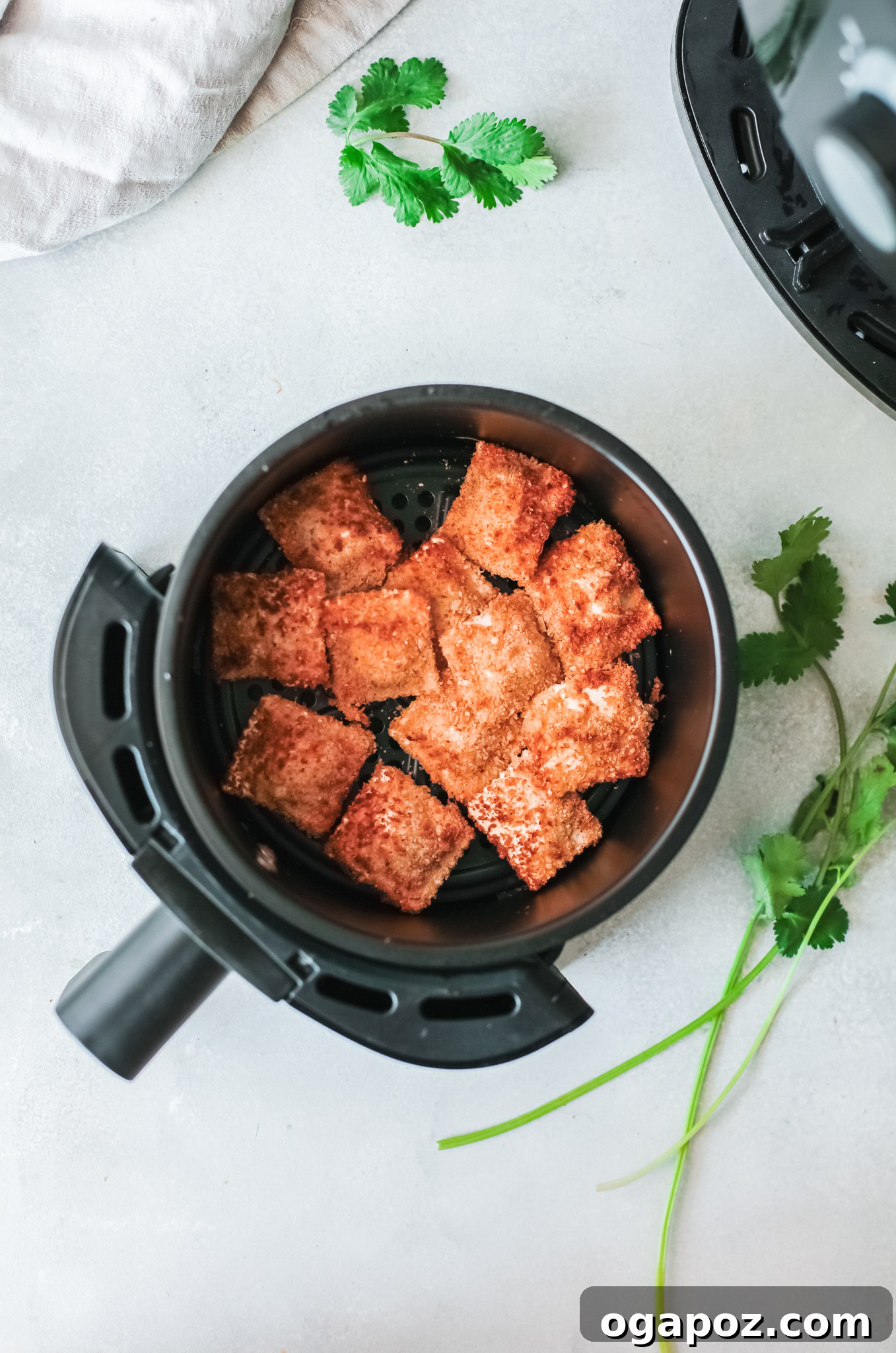 Crispy Air-Fried Ravioli Bites 4 Air Fried Ravioli cooking in an air fryer basket, turning golden brown.