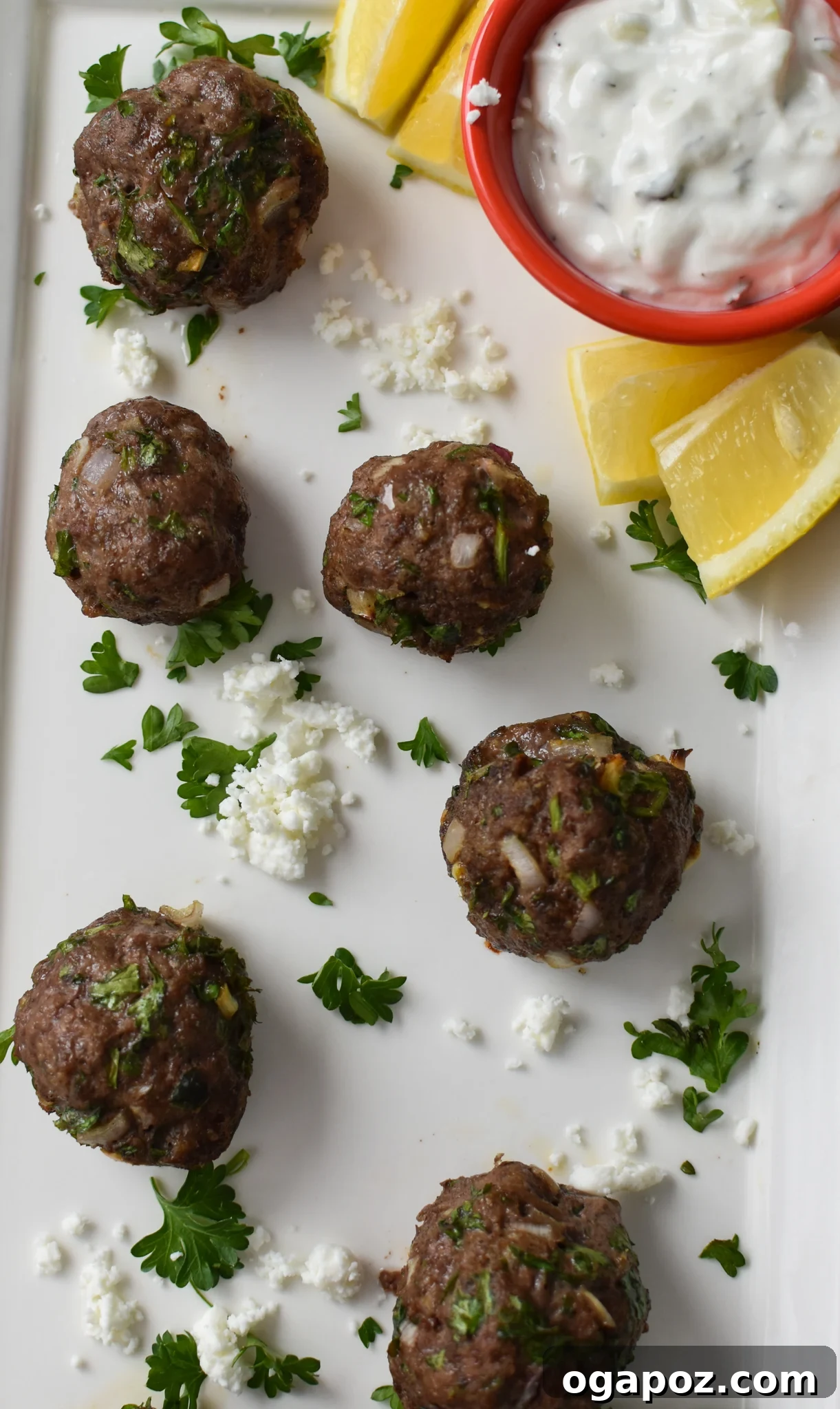 Succulent Mediterranean Baked Beef Meatballs 7 A large white platter generously filled with perfectly baked Mediterranean Beef Meatballs, ready to be served.
