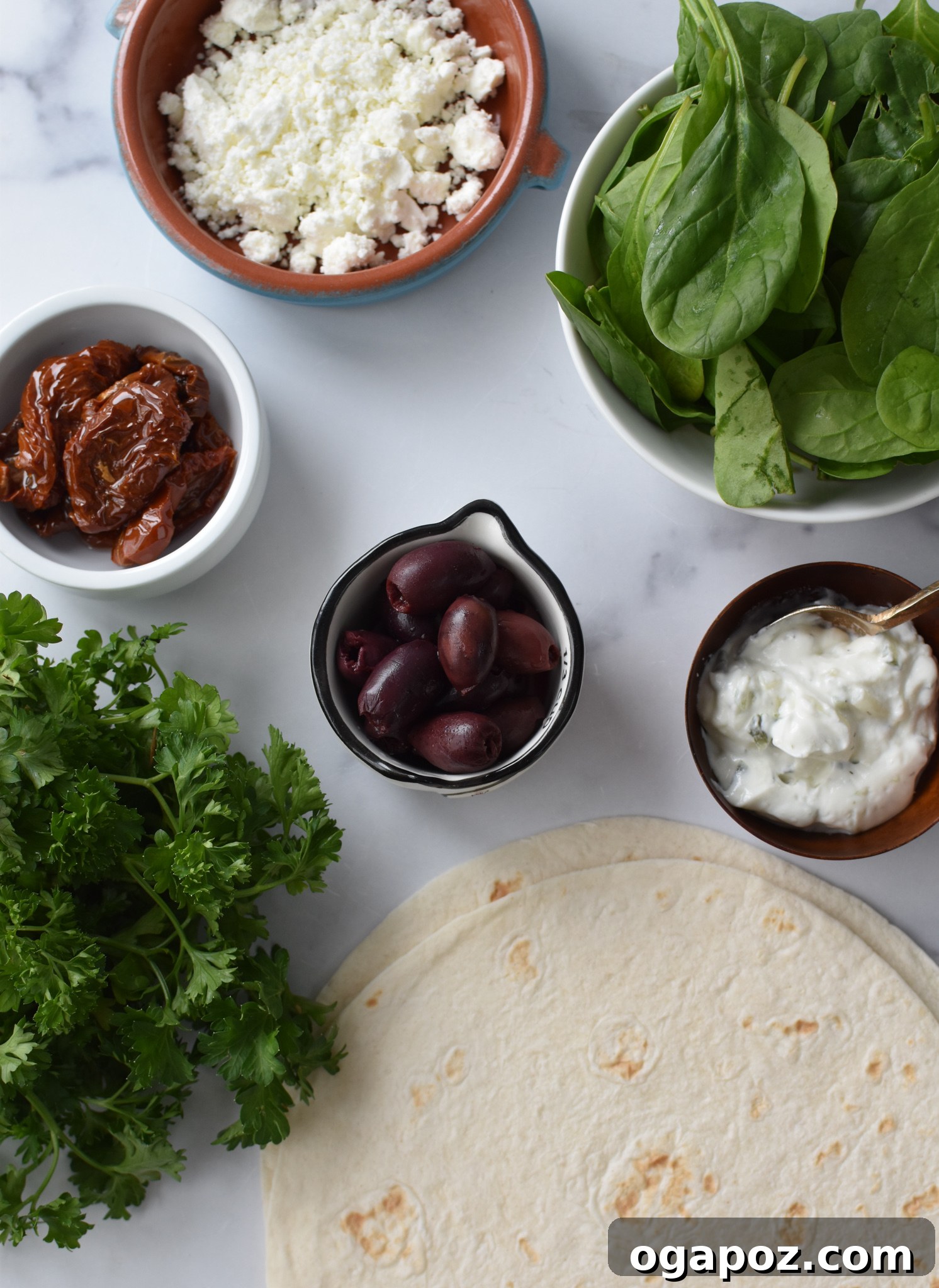 Fresh ingredients for Easy Vegetarian Quesadilla recipe including spinach, sun-dried tomatoes, olives, feta, and tortillas