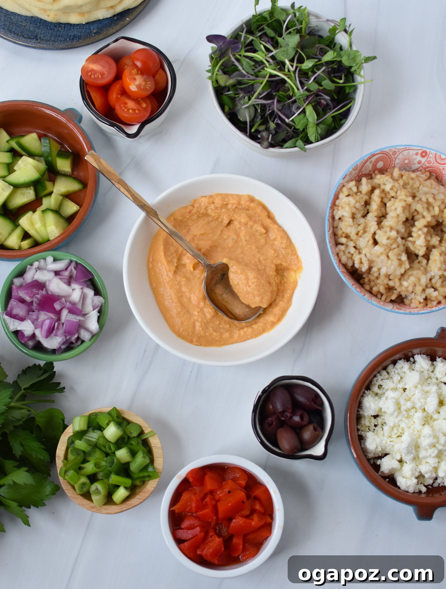 Vibrant Mediterranean Hummus Bowl 3 Fresh ingredients for Easy Mediterranean Hummus Bowl laid out, including chickpeas, feta, vegetables, and herbs.