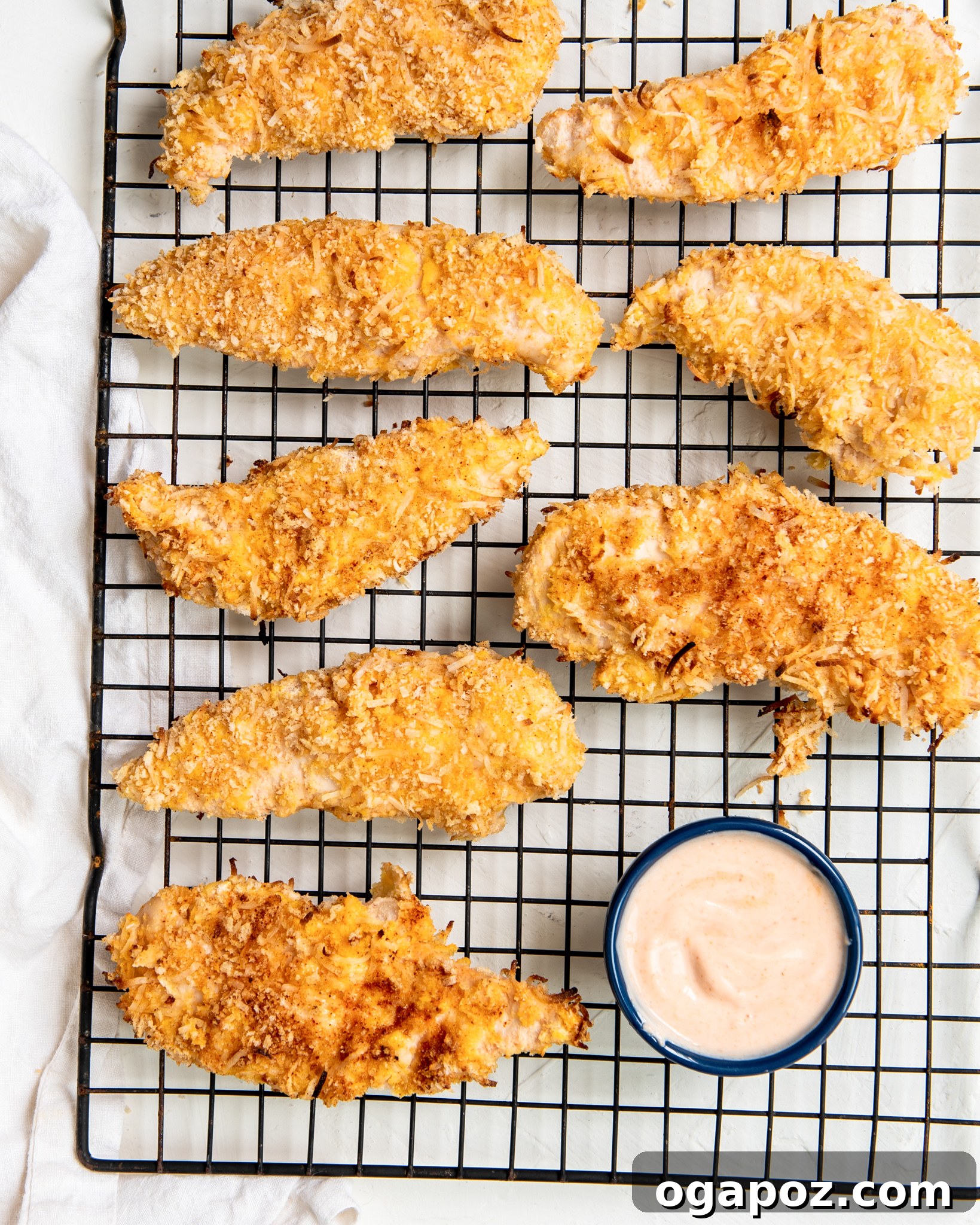 Air-Fried Crispy Coconut Chicken Strips 4 Air Fryer Coconut Chicken Tenders on a baking rack cooling.