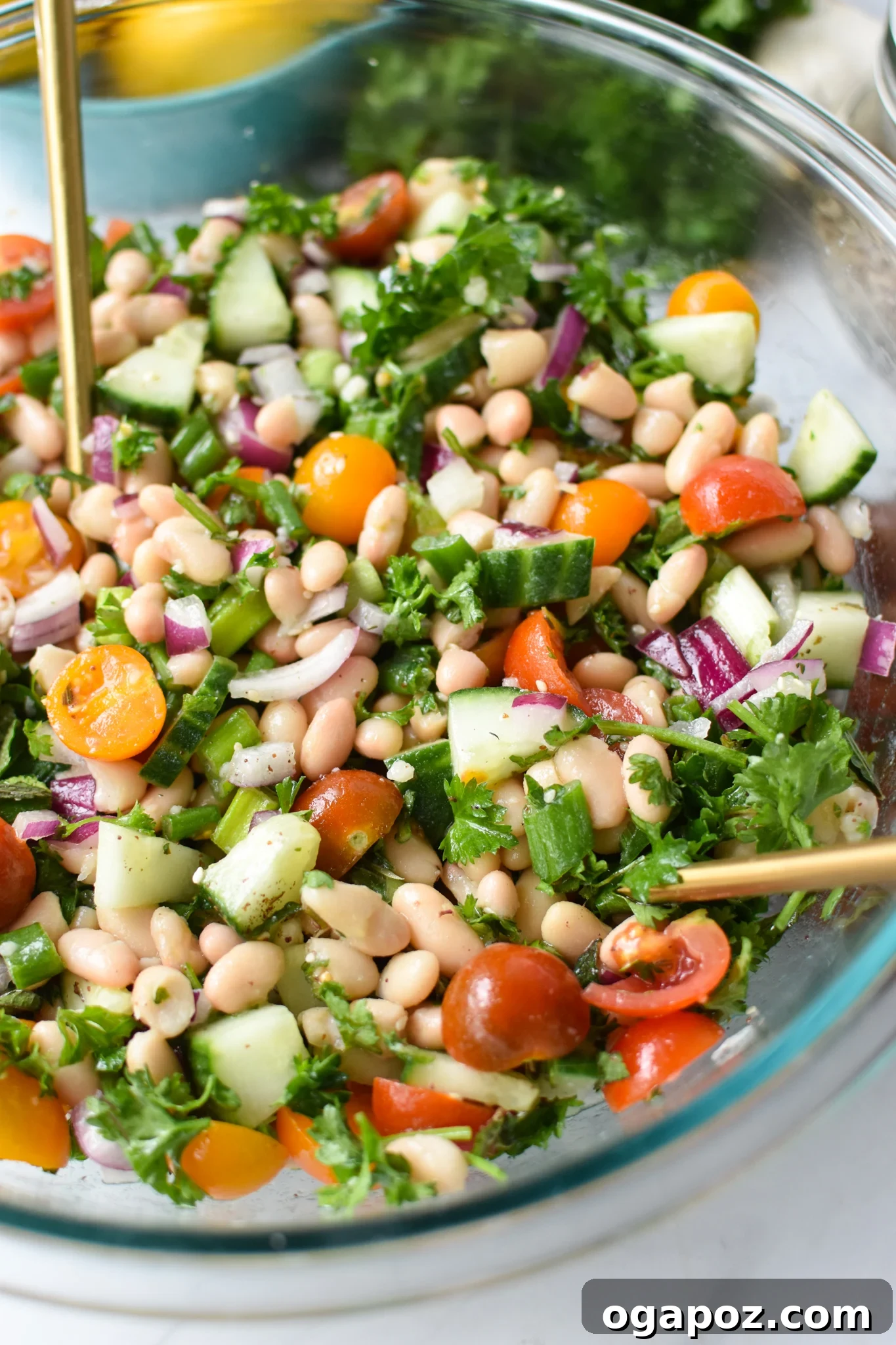 Sun-Drenched Mediterranean White Bean Salad 2 Mediterranean White Bean Salad with gold spoons. A protein-packed salad featuring white beans, fresh vegetables, and a lemon dressing.