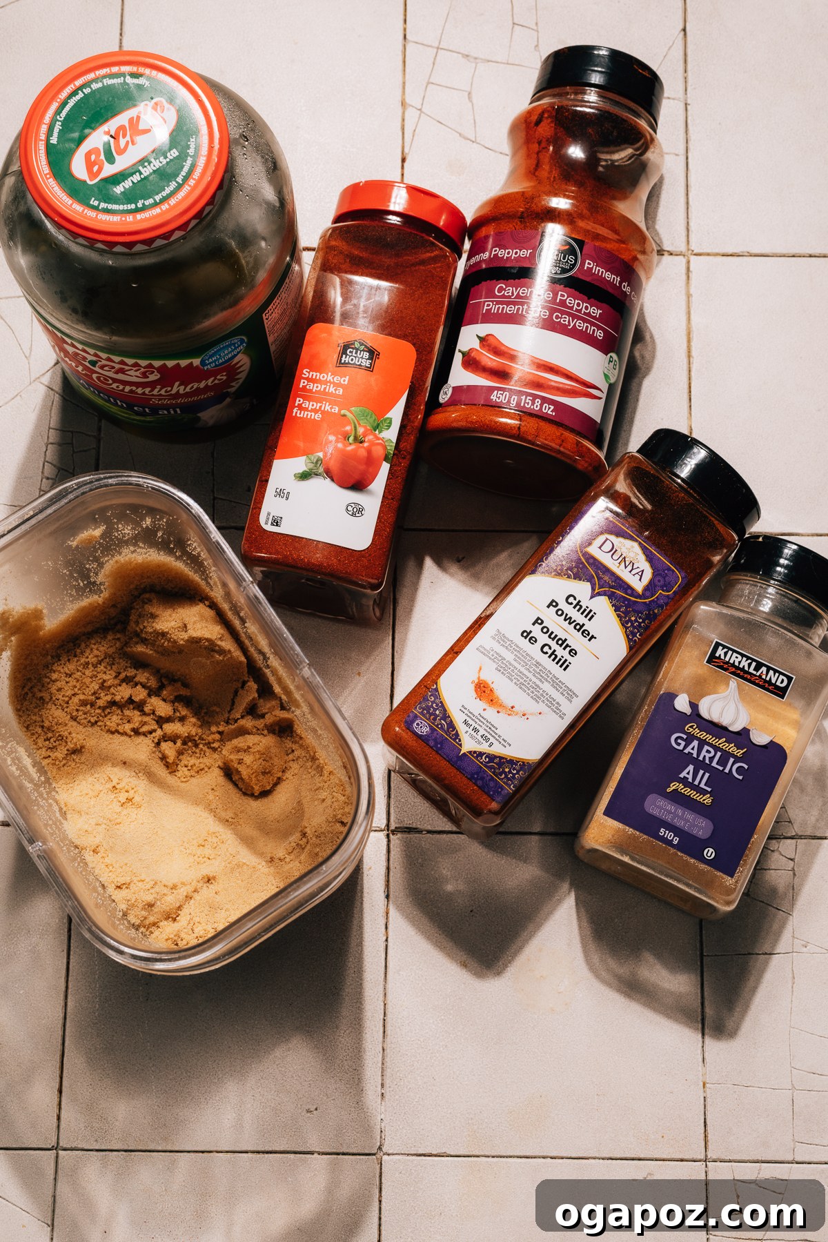 A selection of ingredients laid out for Nashville hot sauce, including oil, spices, and a jar of pickle brine.