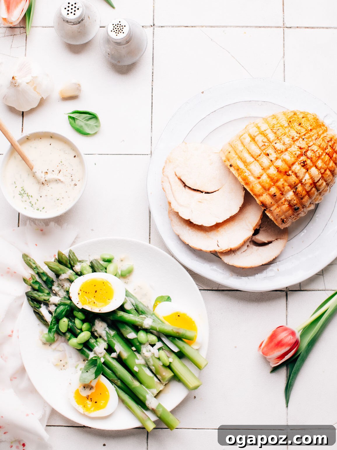Lemon Tahini Dressing served with roasted asparagus and turkey roast, showcasing its versatility.