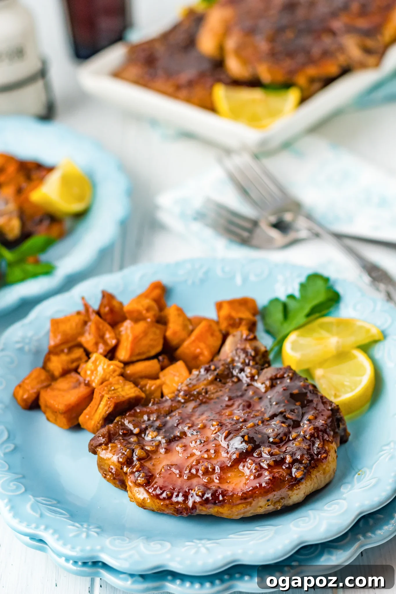 Maple Bourbon Pork Chops served on a blue plate, garnished.