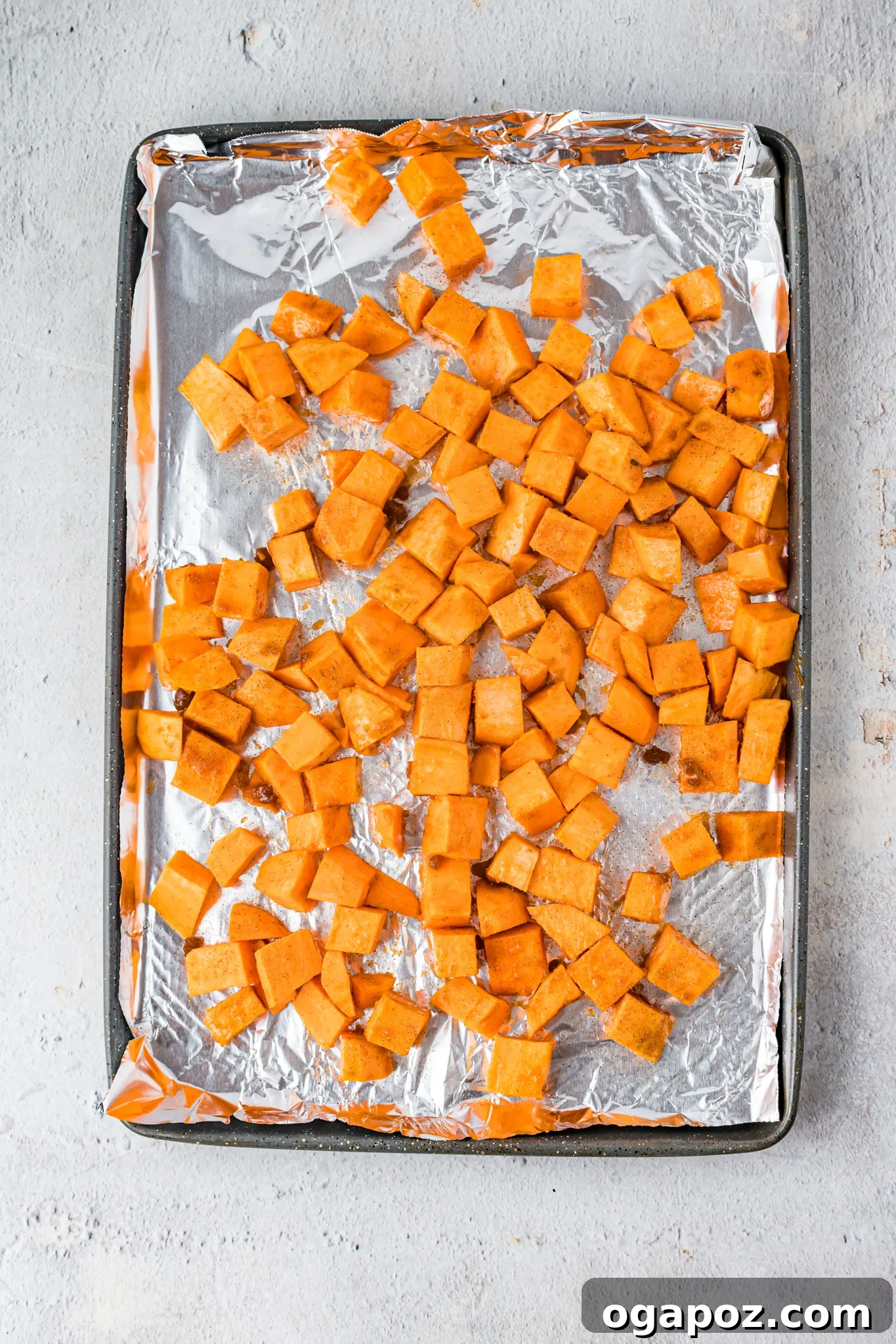 Maple Bourbon Pork Chops Recipe sweet potatoes on a baking sheet.