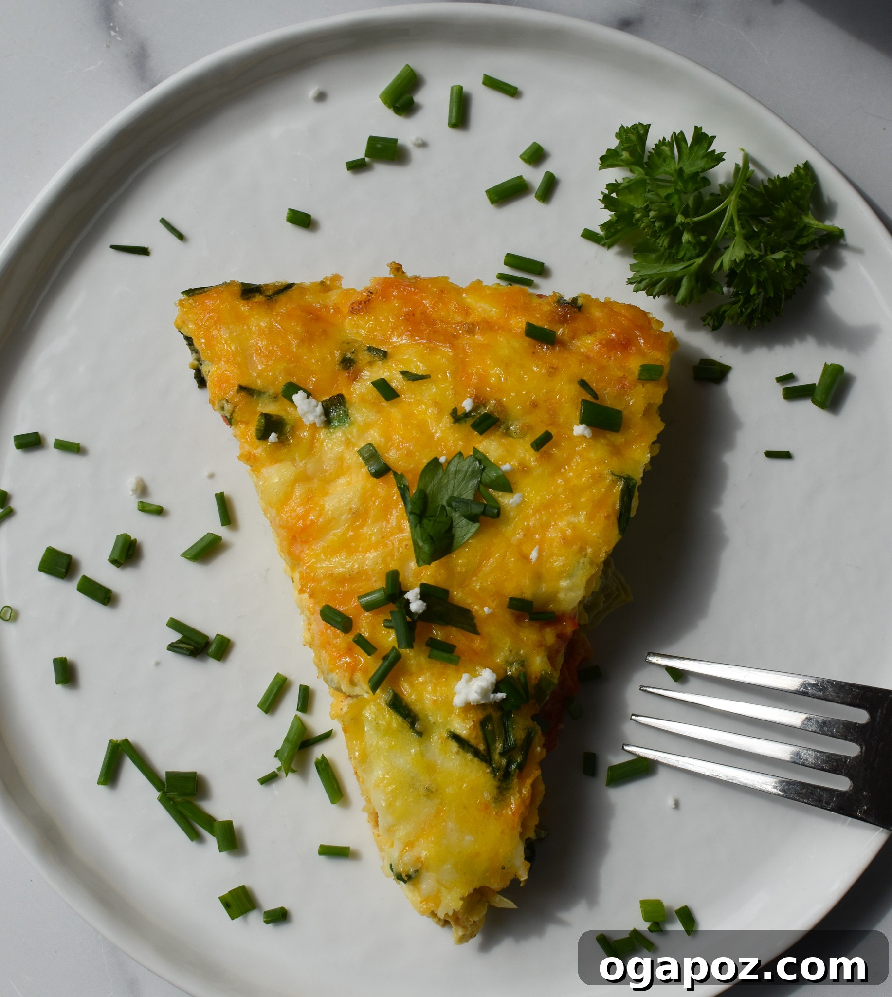 Mediterranean Vegetable Frittata Recipe with a fork on a white plate, ready to be eaten.