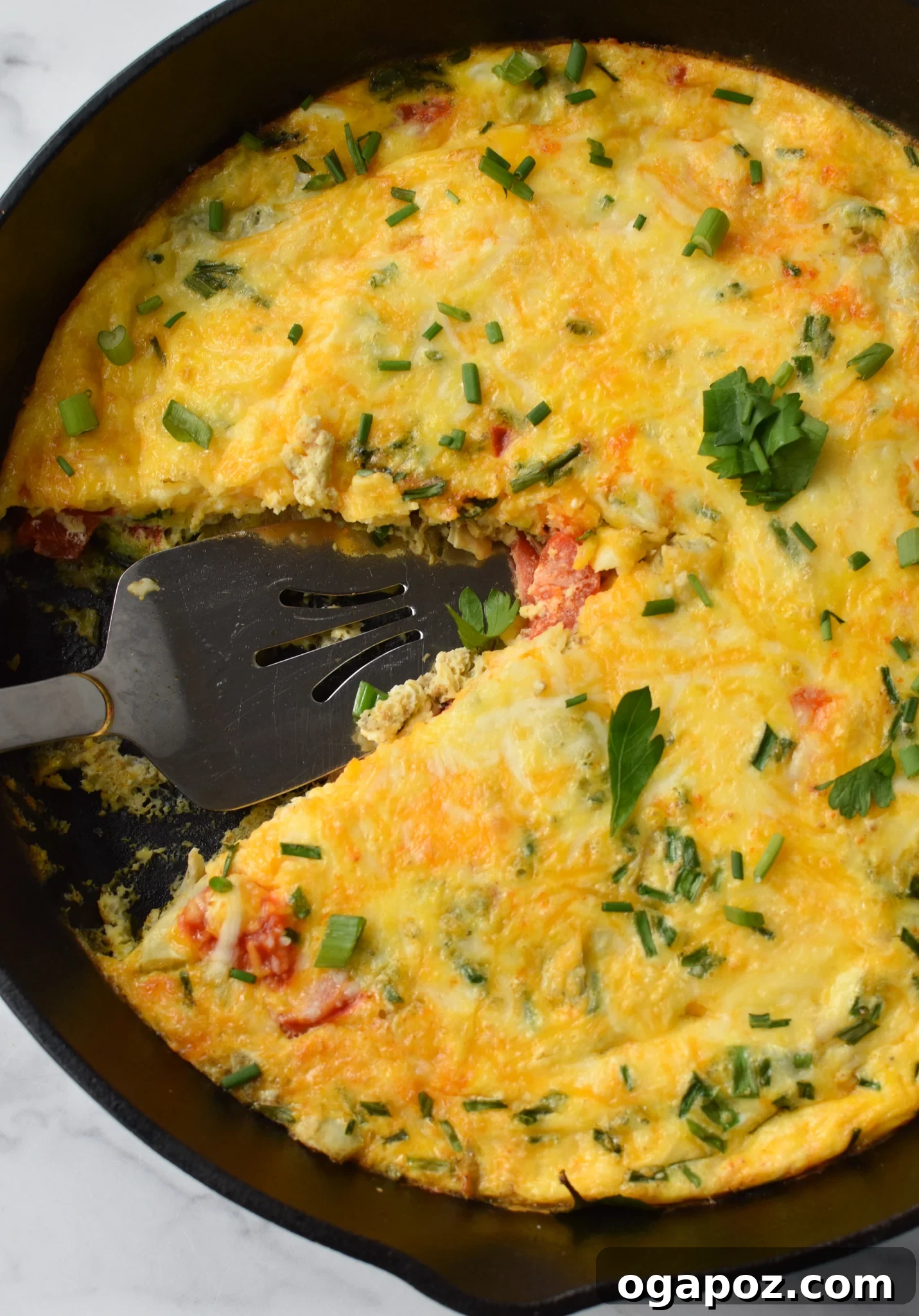 A Mediterranean Vegetable Frittata Recipe being sliced with a pie cutter.