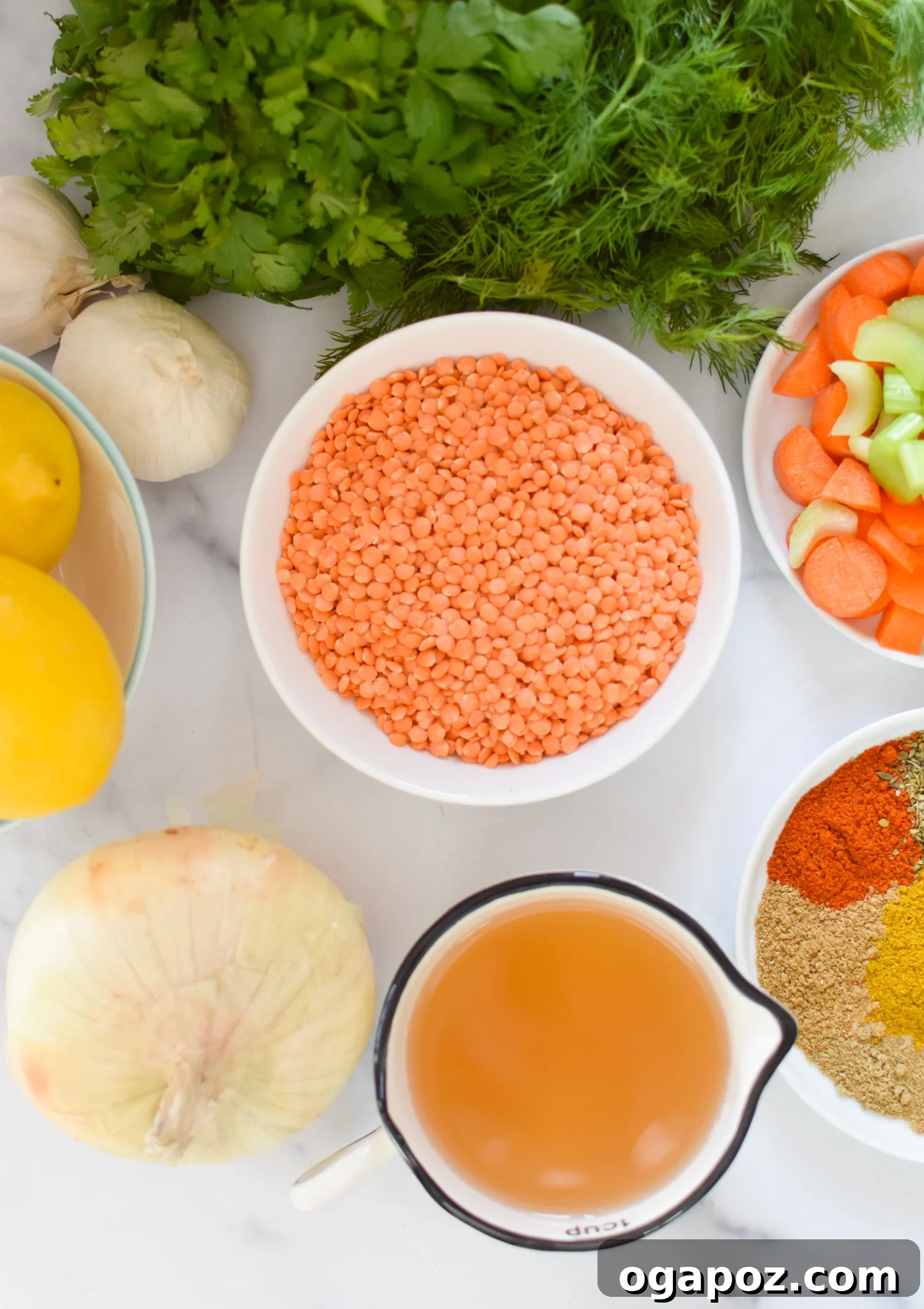 Bright and Zesty Lentil Soup 3 A vibrant selection of Lemon Lentil Soup ingredients laid out on a table, including red lentils, fresh vegetables, garlic, and an array of colorful spices.
