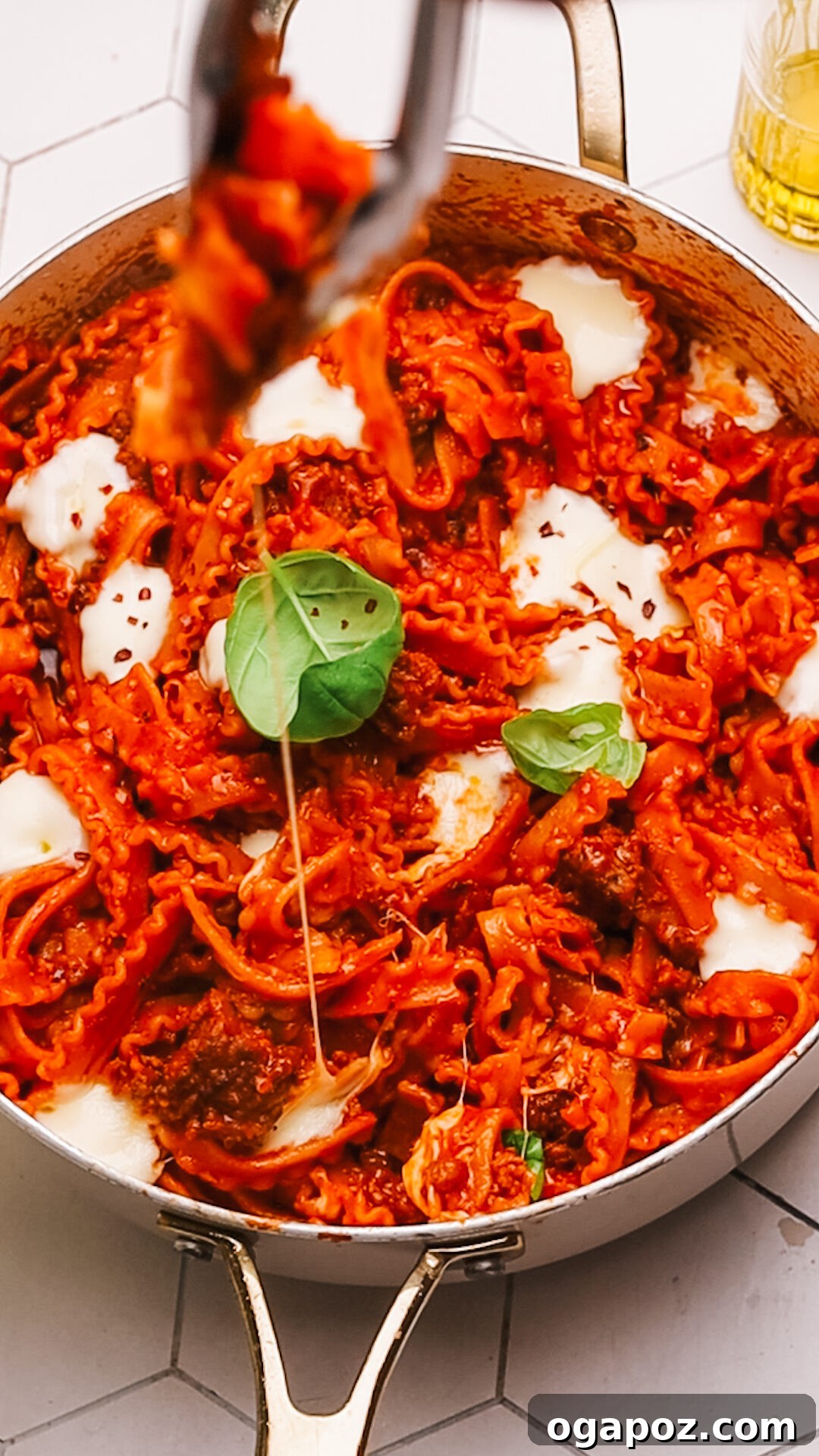 Sauce-Simmered Pasta Feast 12 A serving of one pot pasta with meat sauce in a rustic plate, garnished with fresh basil.