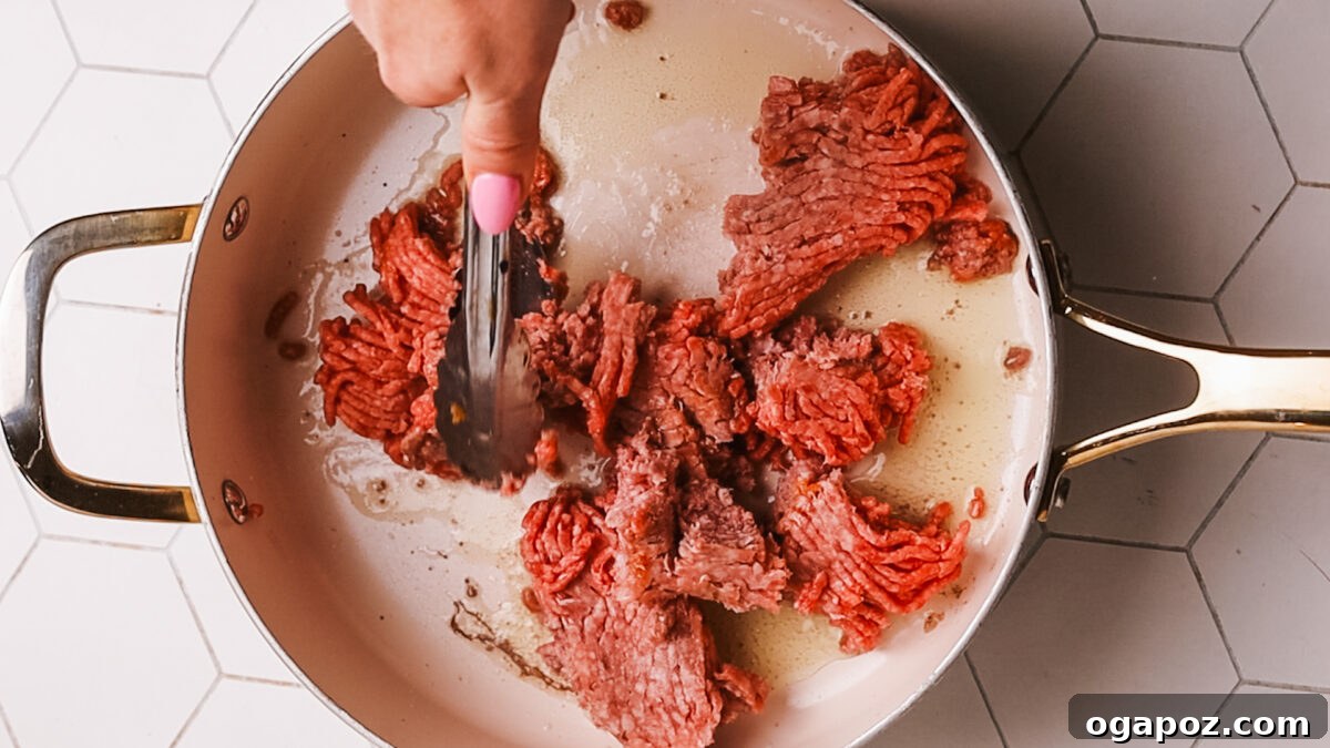 Sauce-Simmered Pasta Feast 5 Breaking down the seared ground beef with a wooden spoon.