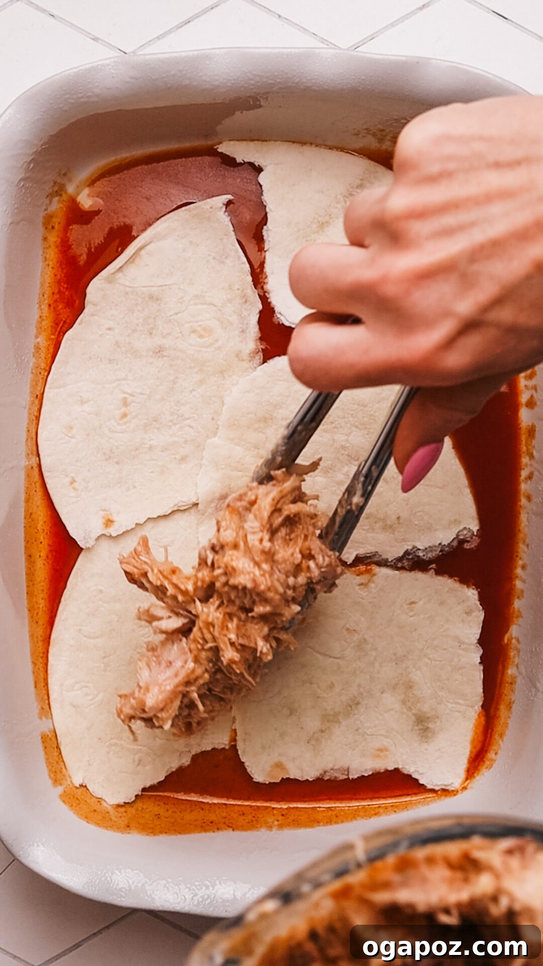 Creamy Chicken Enchilada Bake 6 Layering Chicken Enchilada Casserole in a baking dish.