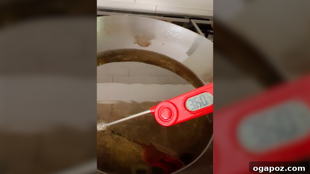 Crispy Fried Cooked Shrimp 6 A thermometer accurately checking the temperature of hot oil in a skillet.