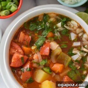 Golden Chicken Potato Comfort 2 A steaming bowl of Hearty Southwest Chicken Potato Soup, garnished with fresh cilantro and lime wedges.