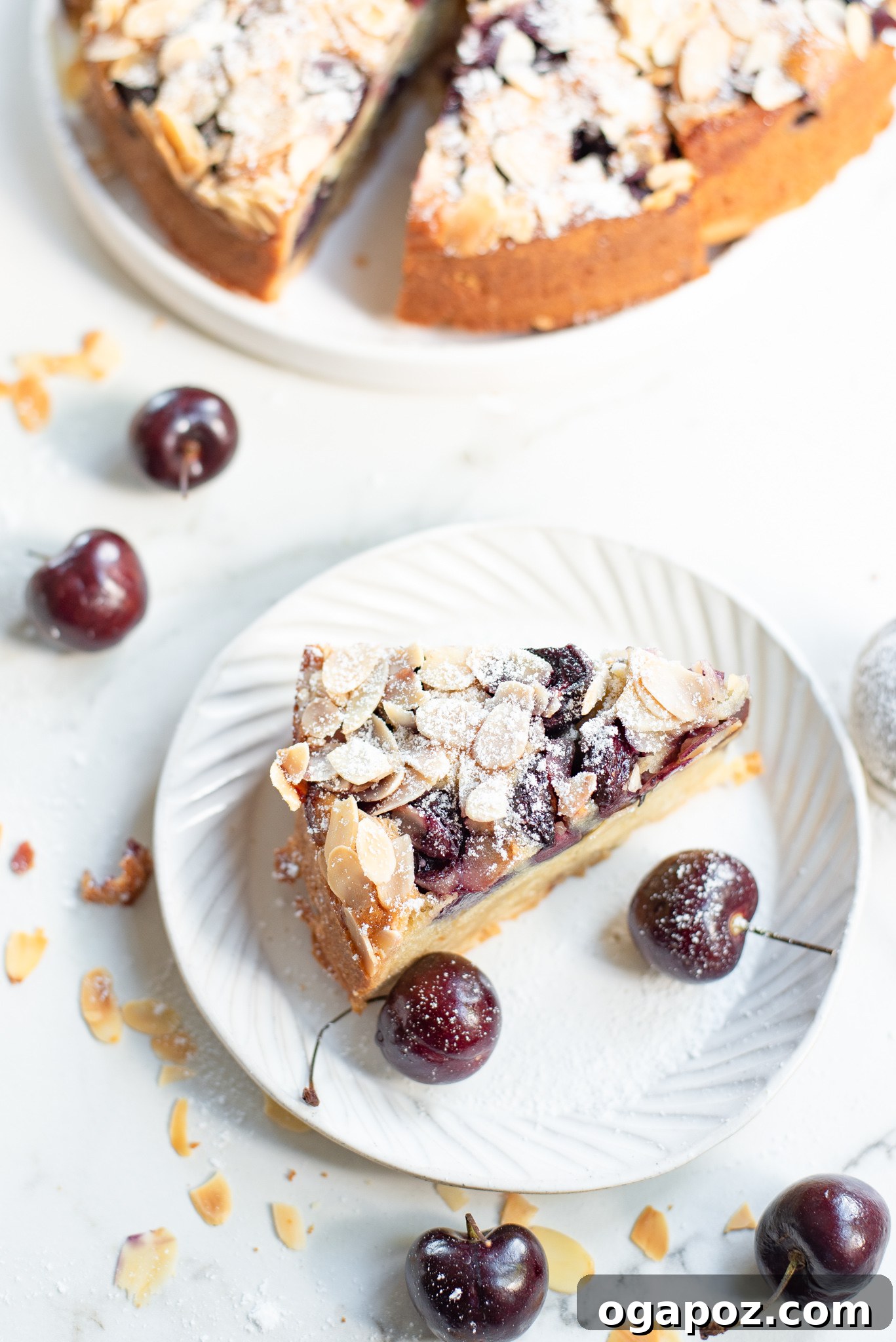 Decadent Cherry Almond Cake 3 A generous piece of Cherry Almond Cake resting on a white plate, highlighting its moist crumb and fruit distribution.