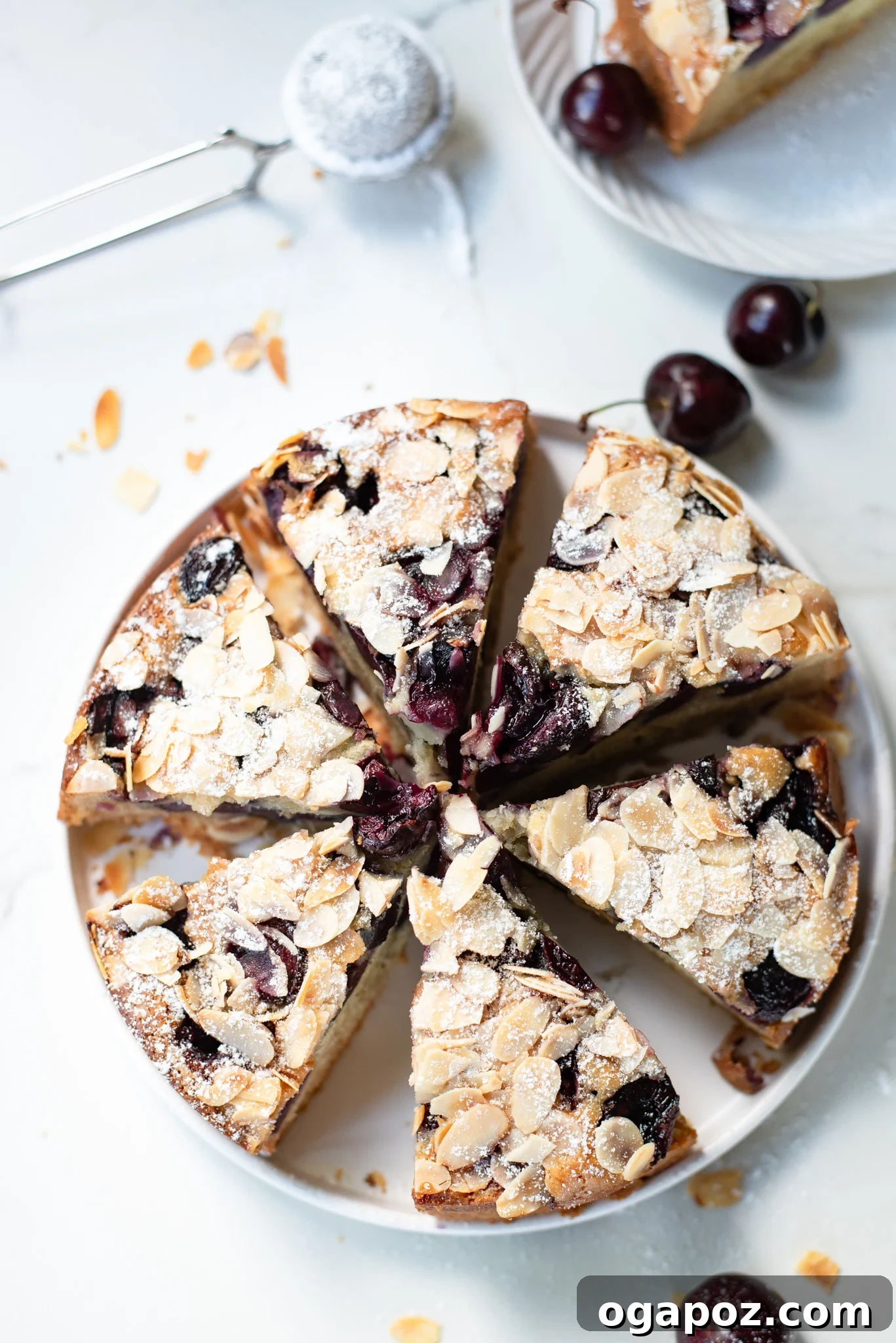 Decadent Cherry Almond Cake 7 A slice of Cherry Almond Cake garnished with fresh cherries and sliced almonds on a rustic plate.
