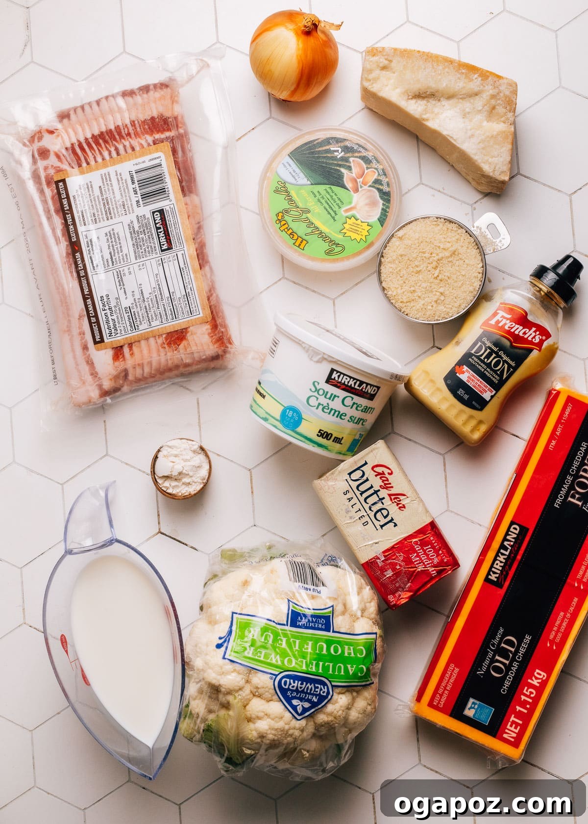 A vibrant selection of fresh ingredients laid out, including cauliflower florets, various cheeses, butter, onion, and garlic, ready for cooking.