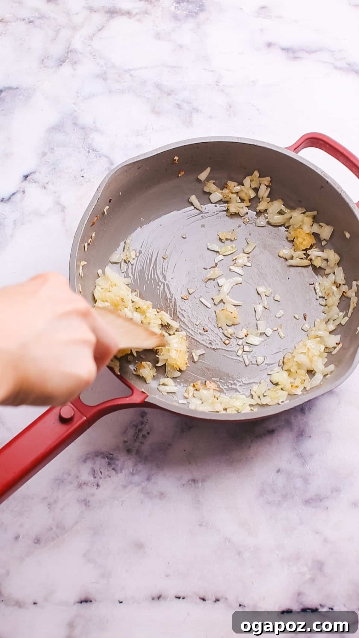Sautéing diced onions and minced garlic in melted butter until fragrant and softened, forming the aromatic base for the cheese sauce.