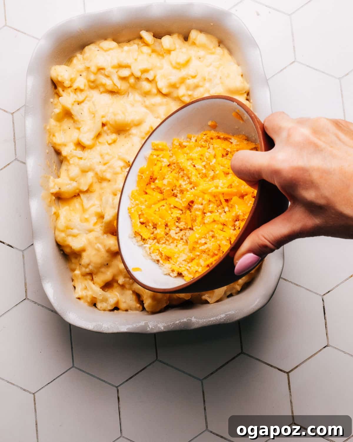 The breadcrumb and cheese topping generously sprinkled over the cauliflower casserole in the baking dish before baking.