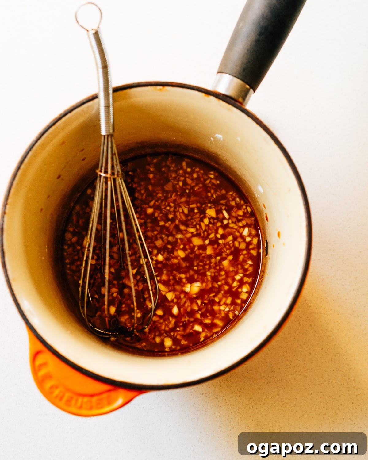 Sweet and Savory Homemade Teriyaki Sauce 4 Making the teriyaki sauce recipe in a saucepan with a whisk, showing the thickening process.