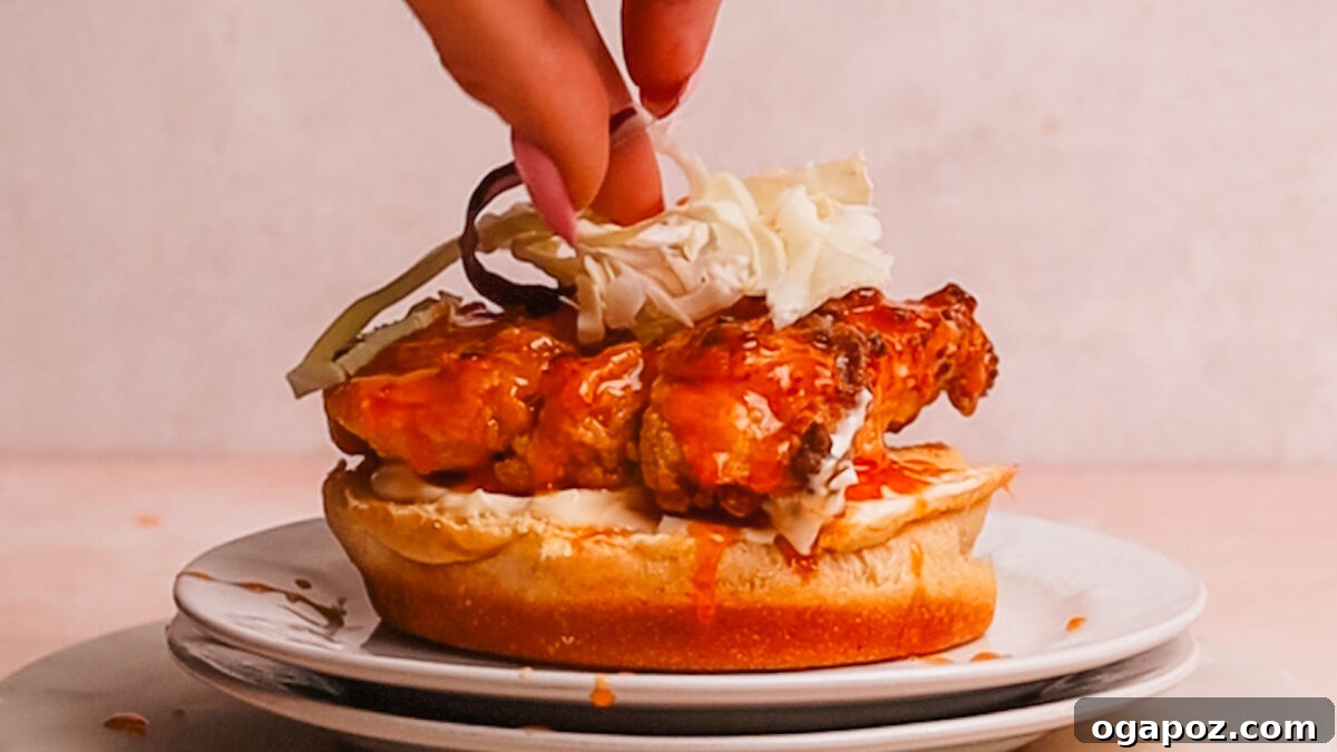 Crispy Sweet Heat Chicken Sandwich 9 Assembling the hot honey chicken sandwich with mayo, chicken, sauce, and pickles.